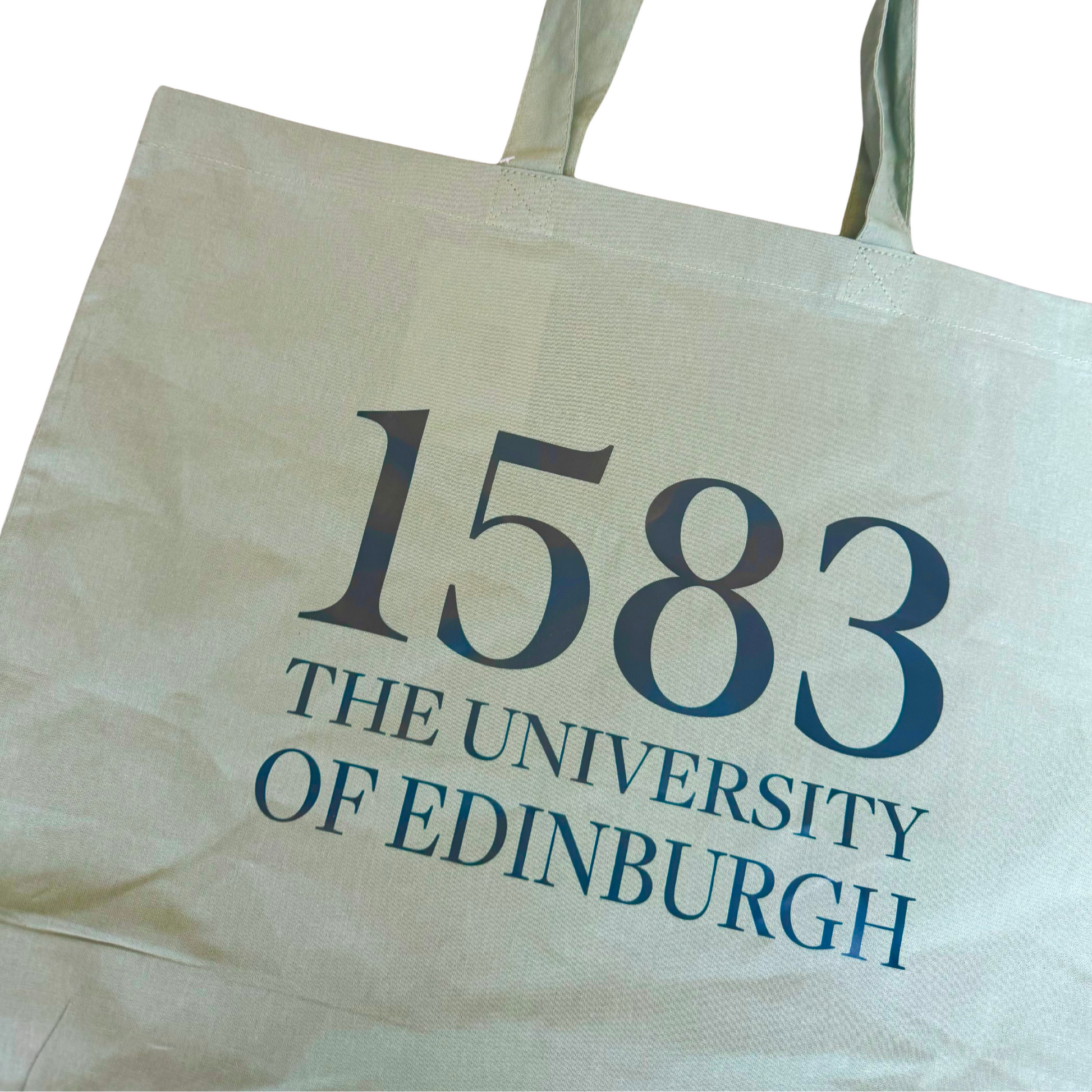 close-up of a Sage green tote bag with large text that says 1583 The University of Edinburgh