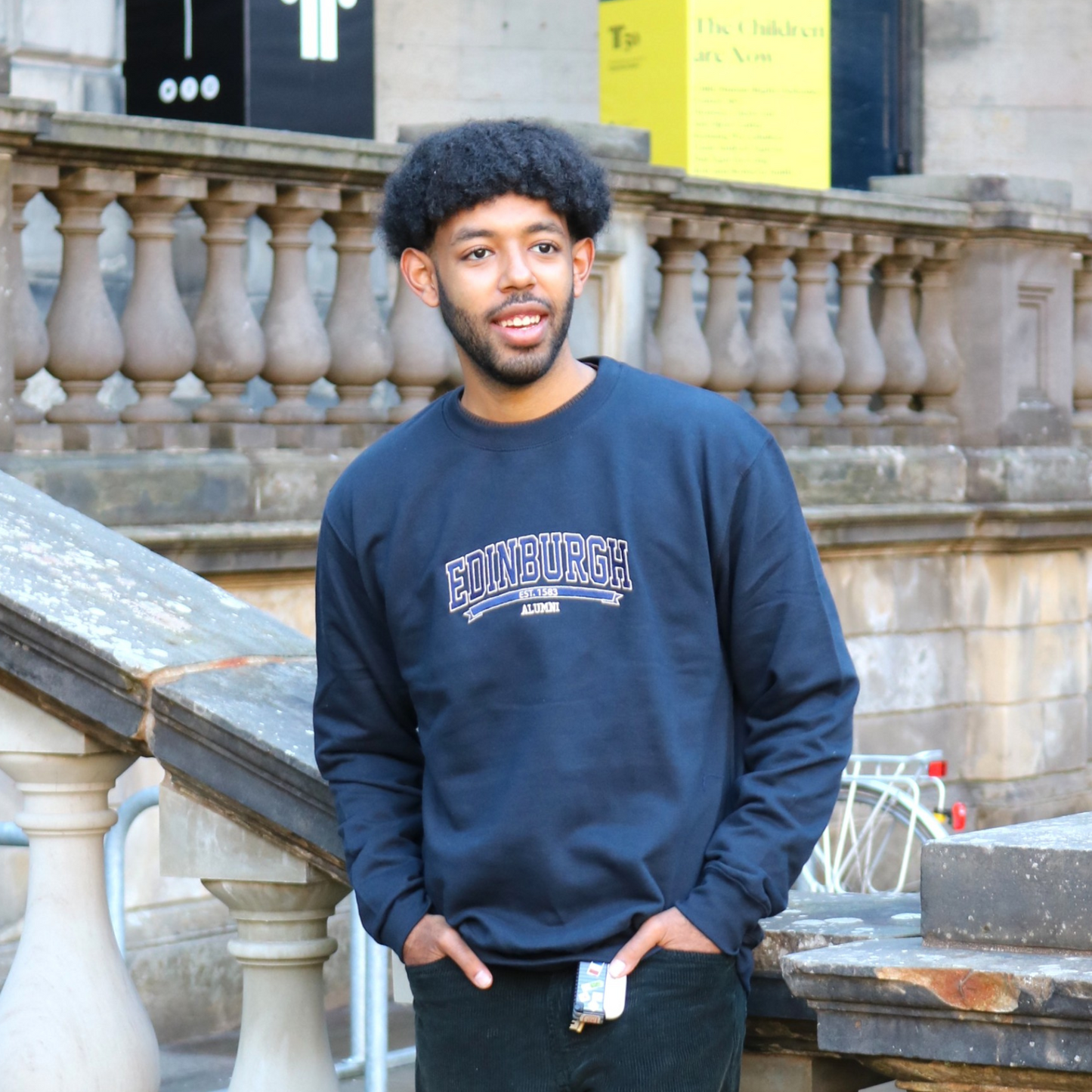 Model wears Embroidered Alumni Sweatshirt in the Old College Quad.