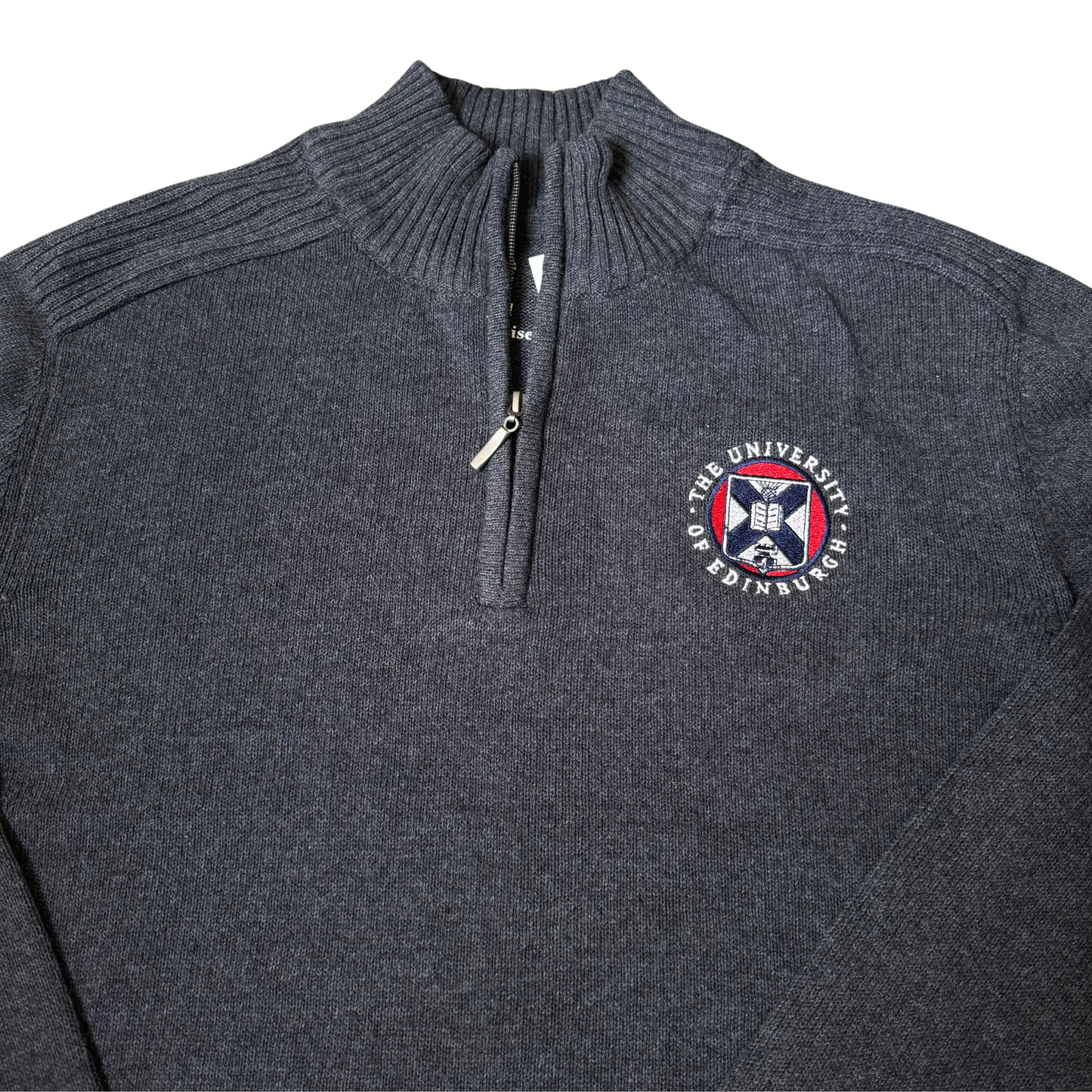 Close up of Charcoal Knitted Quarter Zip Sweatshirt with coloured University Crest on right side of chest.