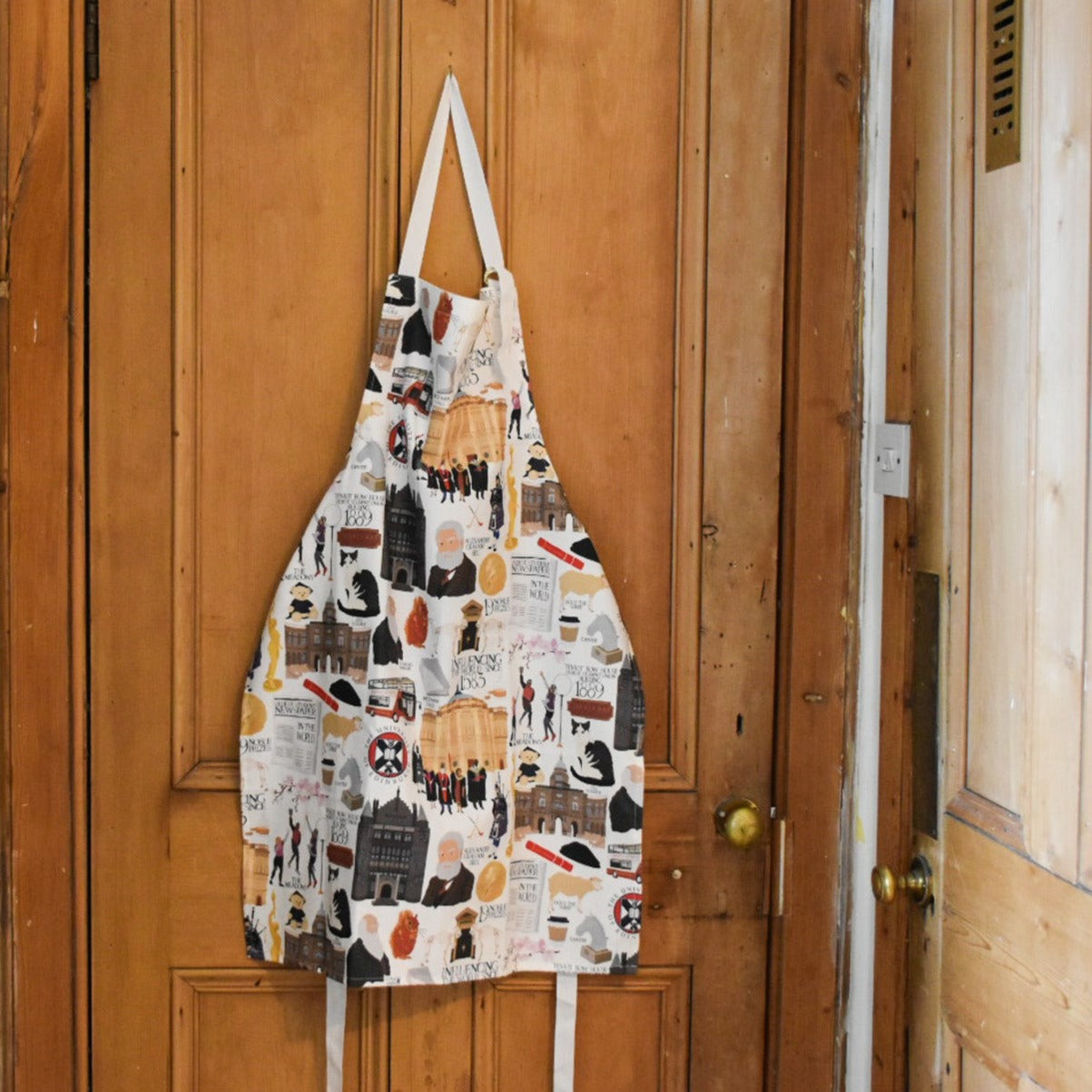 Hanging apron with illustrations of various University of Edinburgh icons, buildings, and figures.