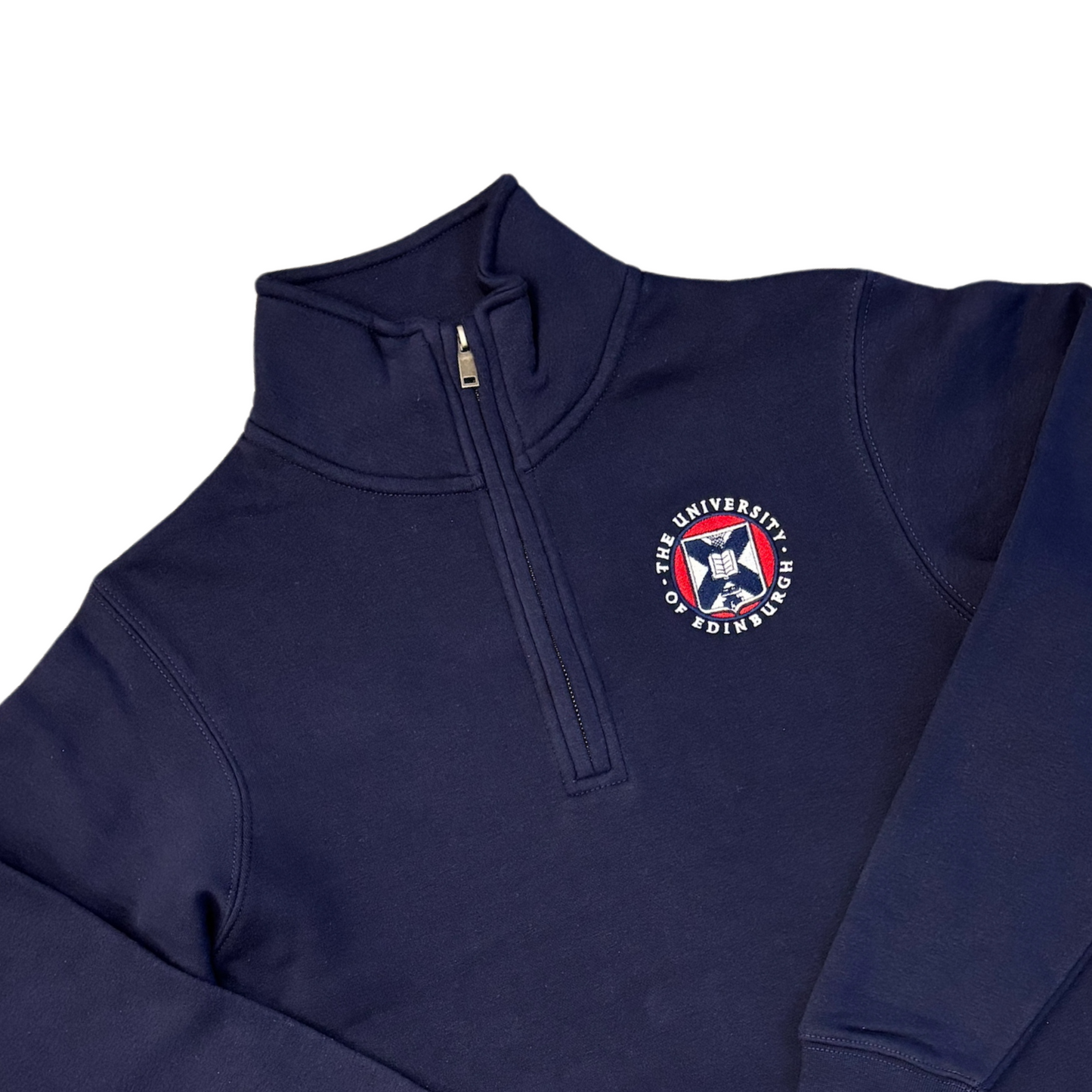 Close up of quarter-zip navy sweatshirt with a full-colour embroidered University of Edinburgh crest on the chest.