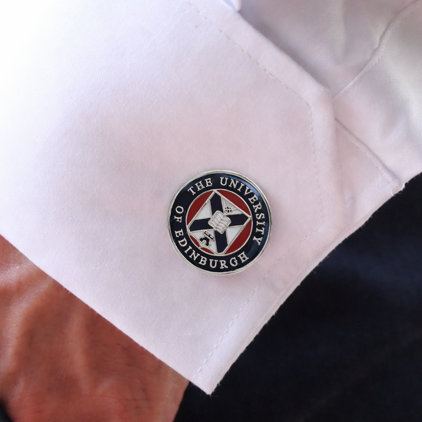 Cufflink with 'The University of Edinburgh' logo on a white shirt cuff.