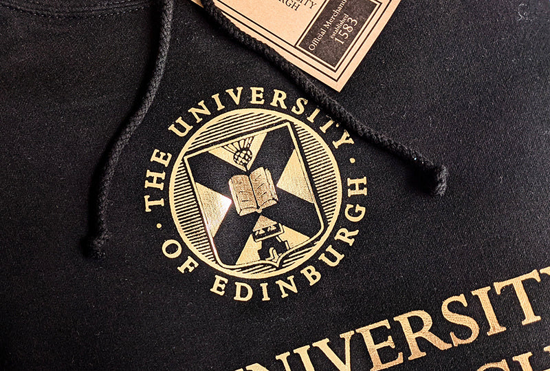 The University crest on our black and gold foil hoodie