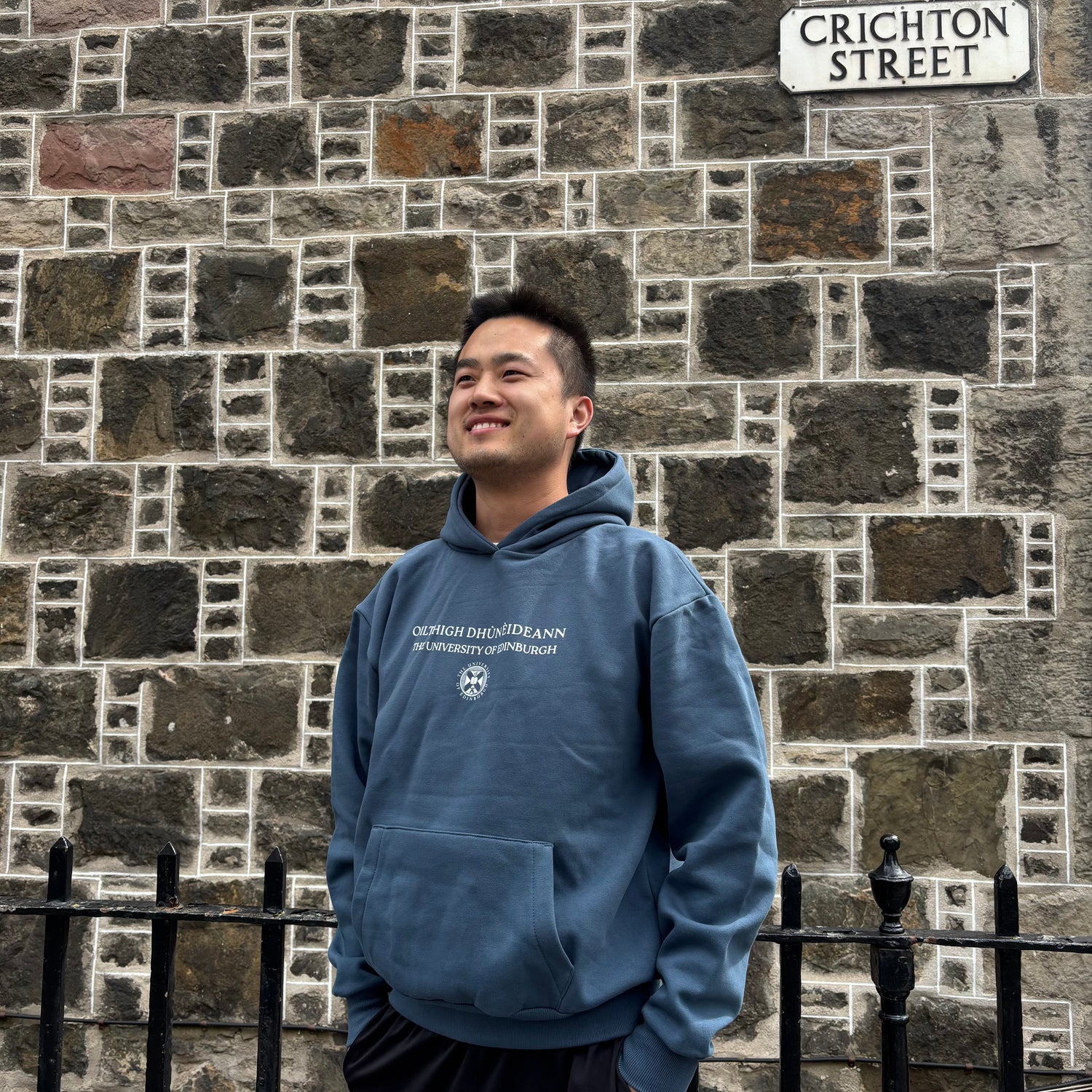 Model wears Gaelic Bilingual Hoodie in Air Force blue.