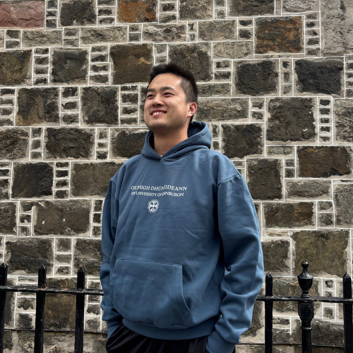 Model wears Gaelic Bilingual Hoodie in Air Force blue.