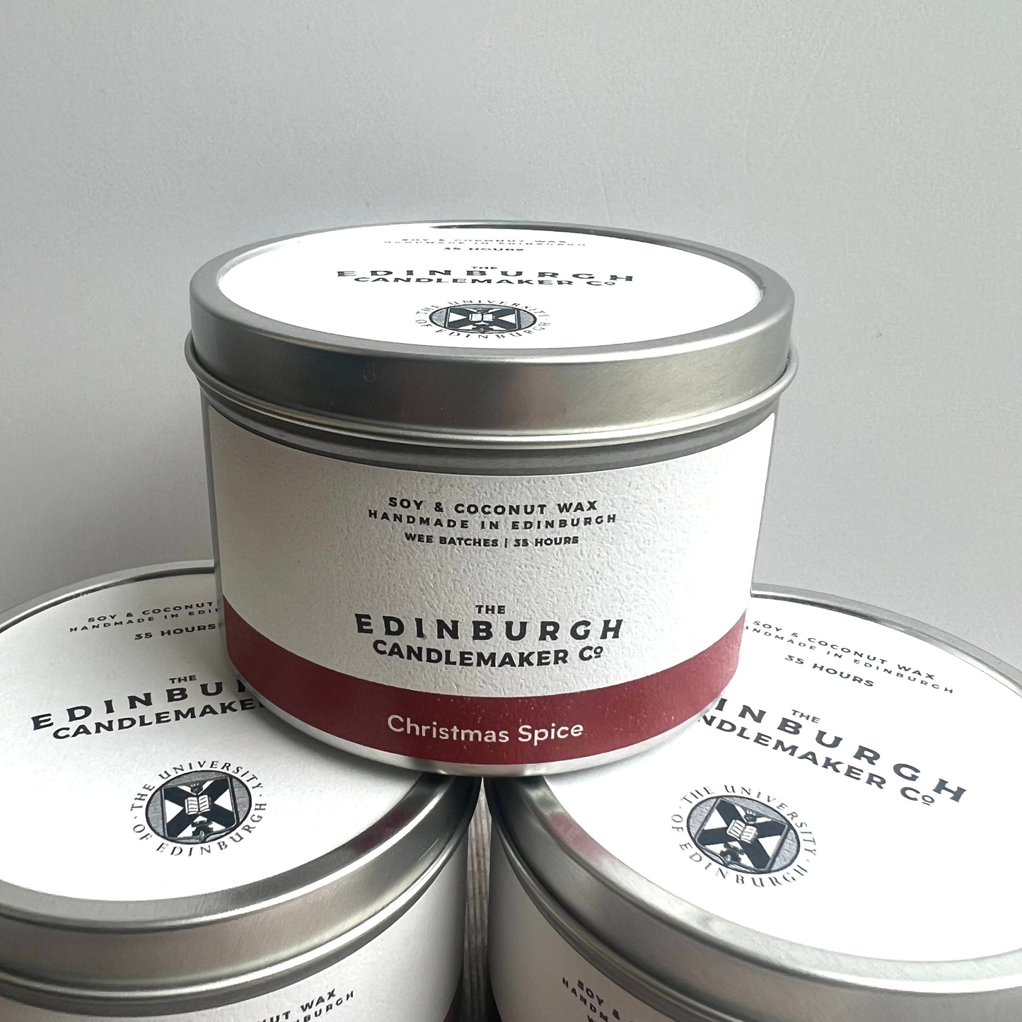 christmas spice candle in silver tin with white label.