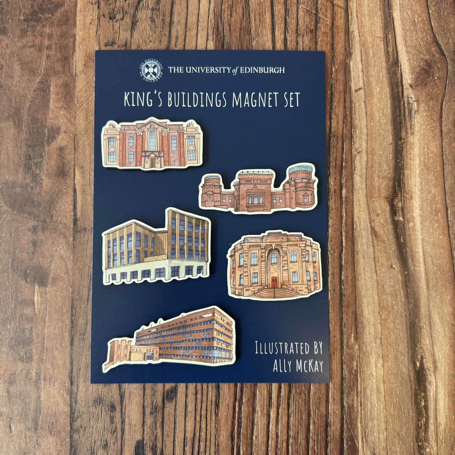 The King's Building magnet set on a navy backing card. The set features magnets of Ally McKay's illustrations of The Nucleus, Joseph Black Building, James Clerk Maxwell Building, Ashworth Building and The Royal Observatory.