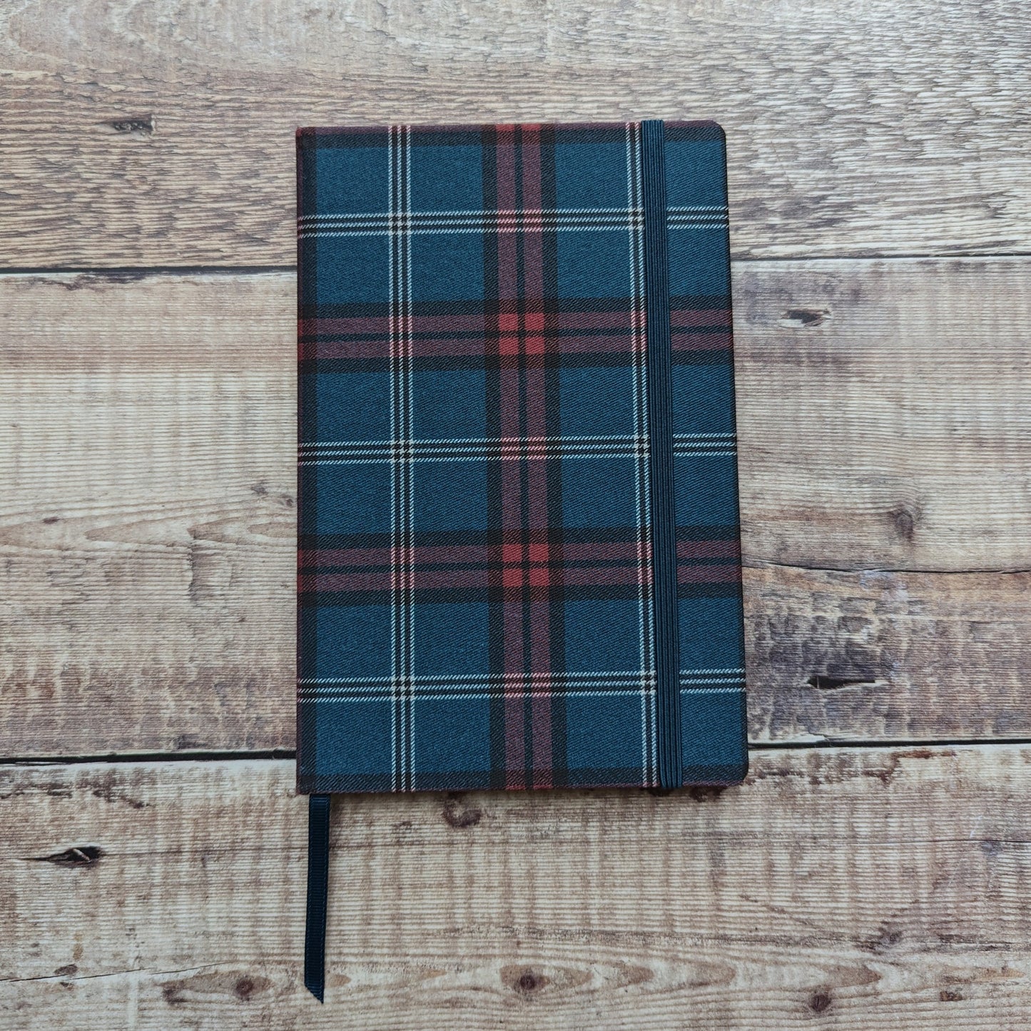 Cloth-bound tartan notebook is A5 in size with a matching elastic strap and fully lined pages.