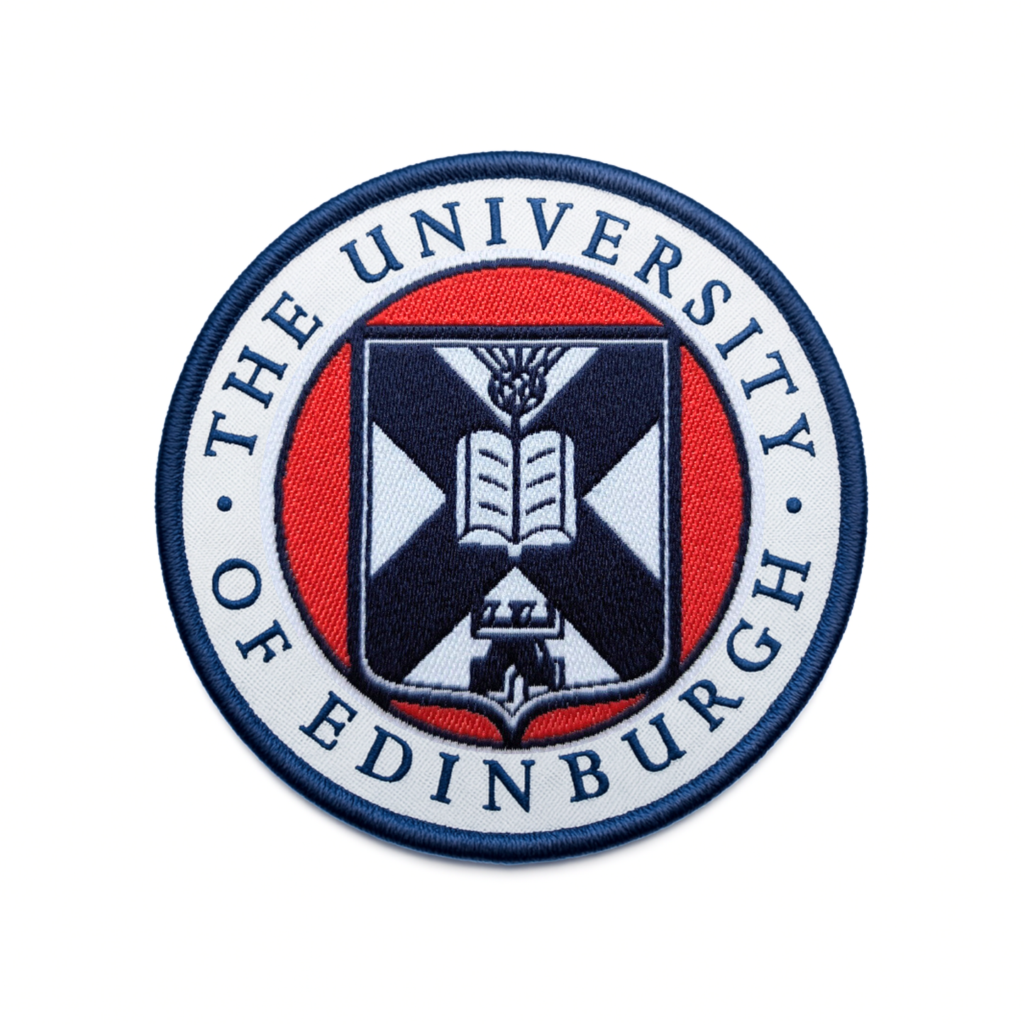 close up of the white, red, and navy woven university crest patch on a white background