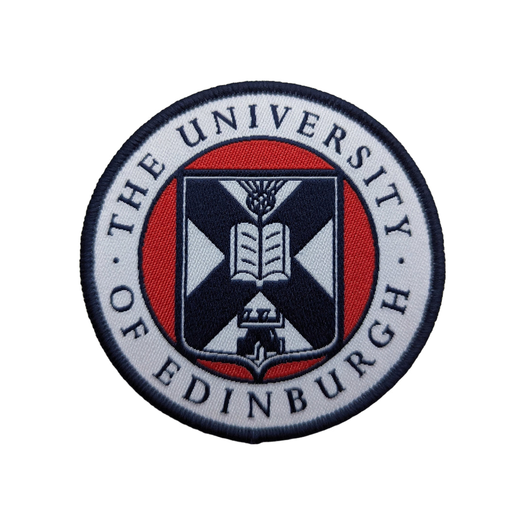 close up of the white, red, and navy woven university crest patch on a white background