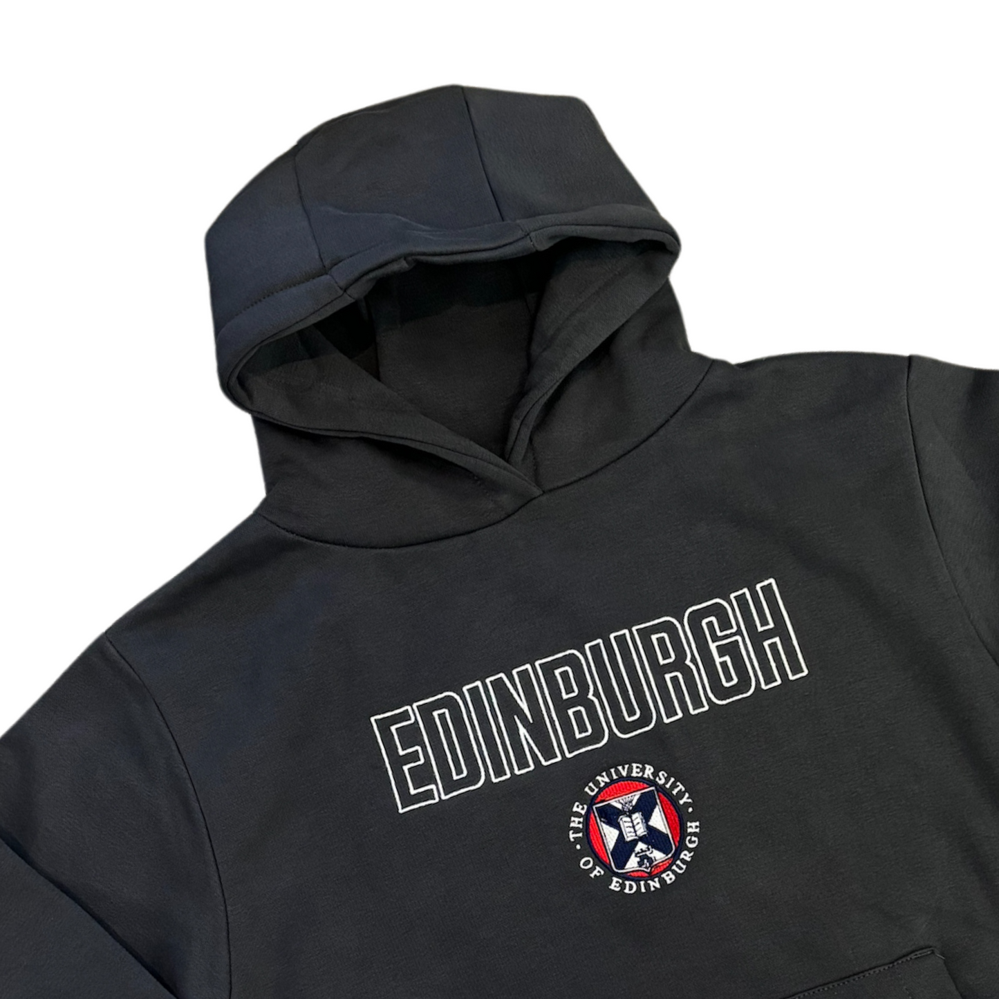 Close up of 'EDINBURGH' in white outlined text in center of the garment, with a full colour University crest underneath it.