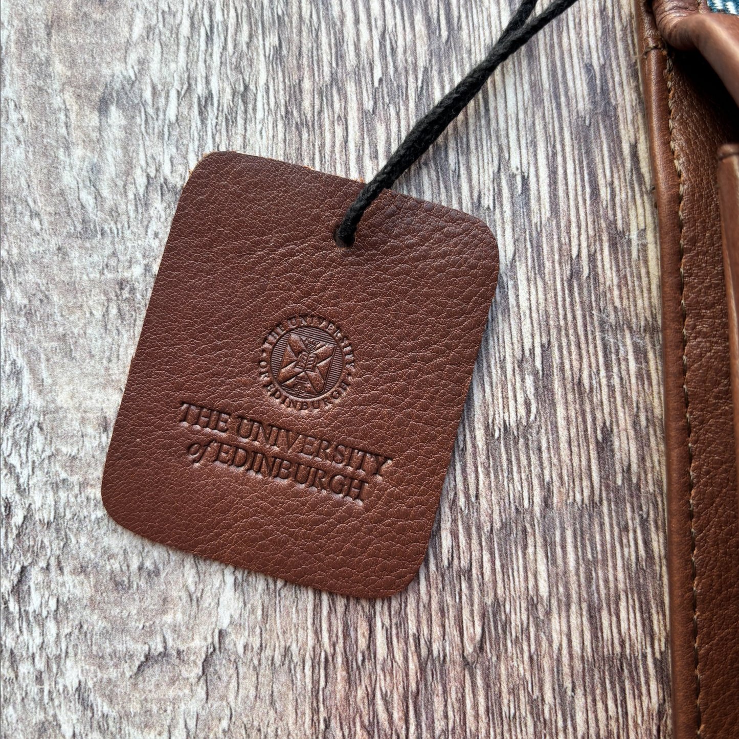The leather tag has the University crest and logo embossed.