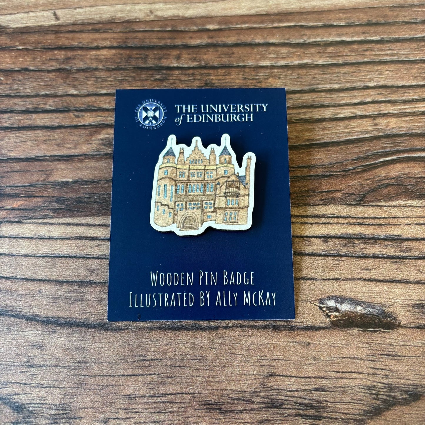 The Teviot Row House wooden pin badge on its backing card.