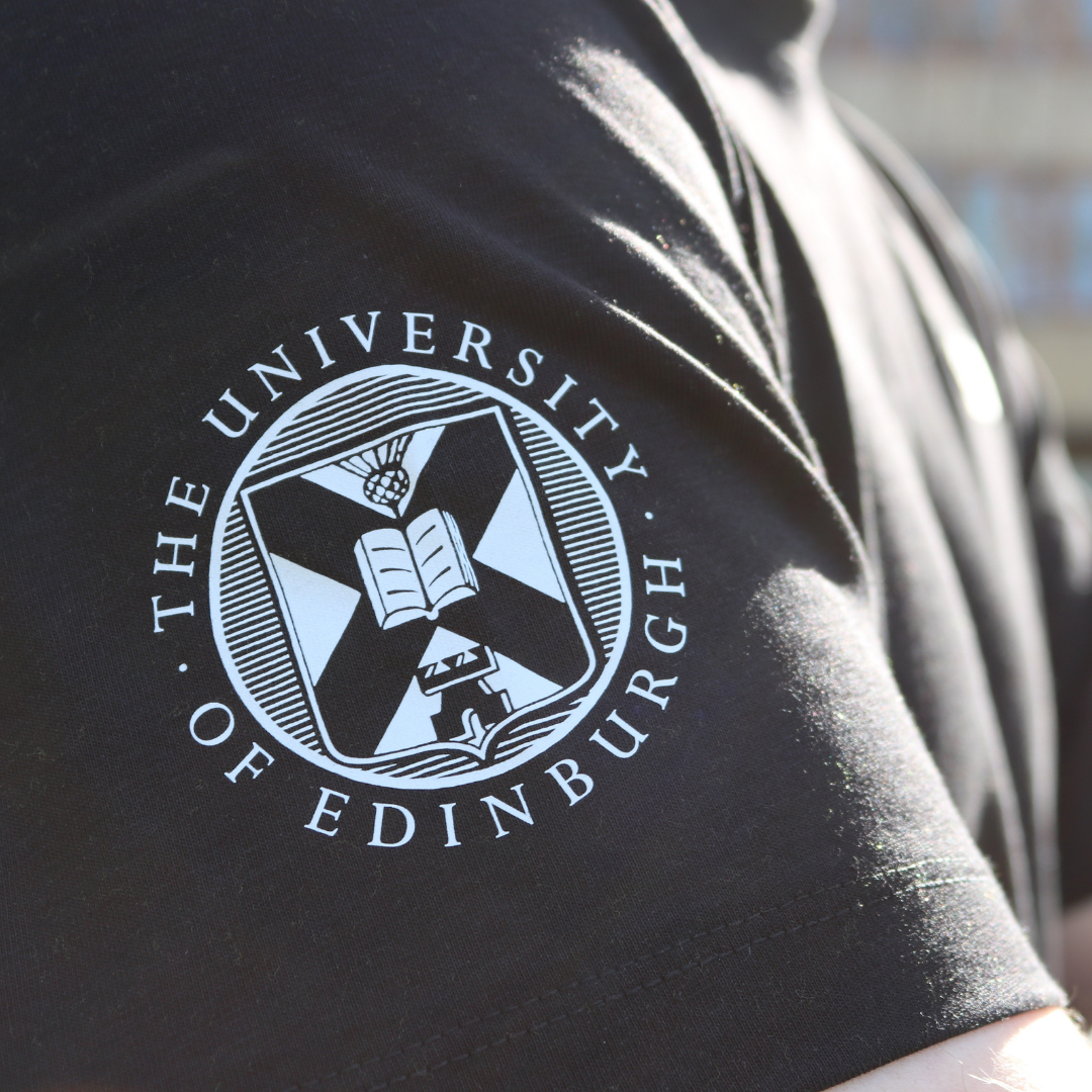 Black shirt sleeve with The University of Edinburgh crest on a blurred background