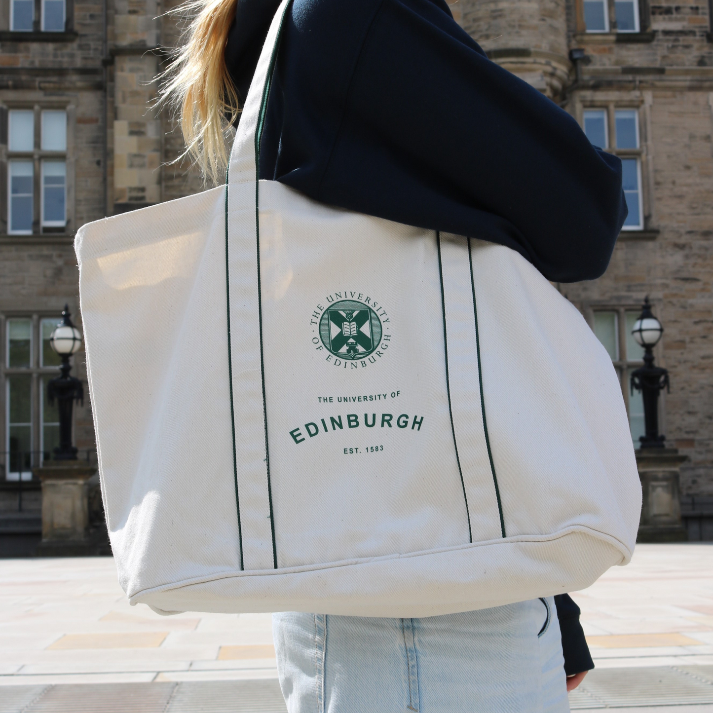 Model carries Established Courtside Tote Bag in front of Edinburgh Futures Institute.