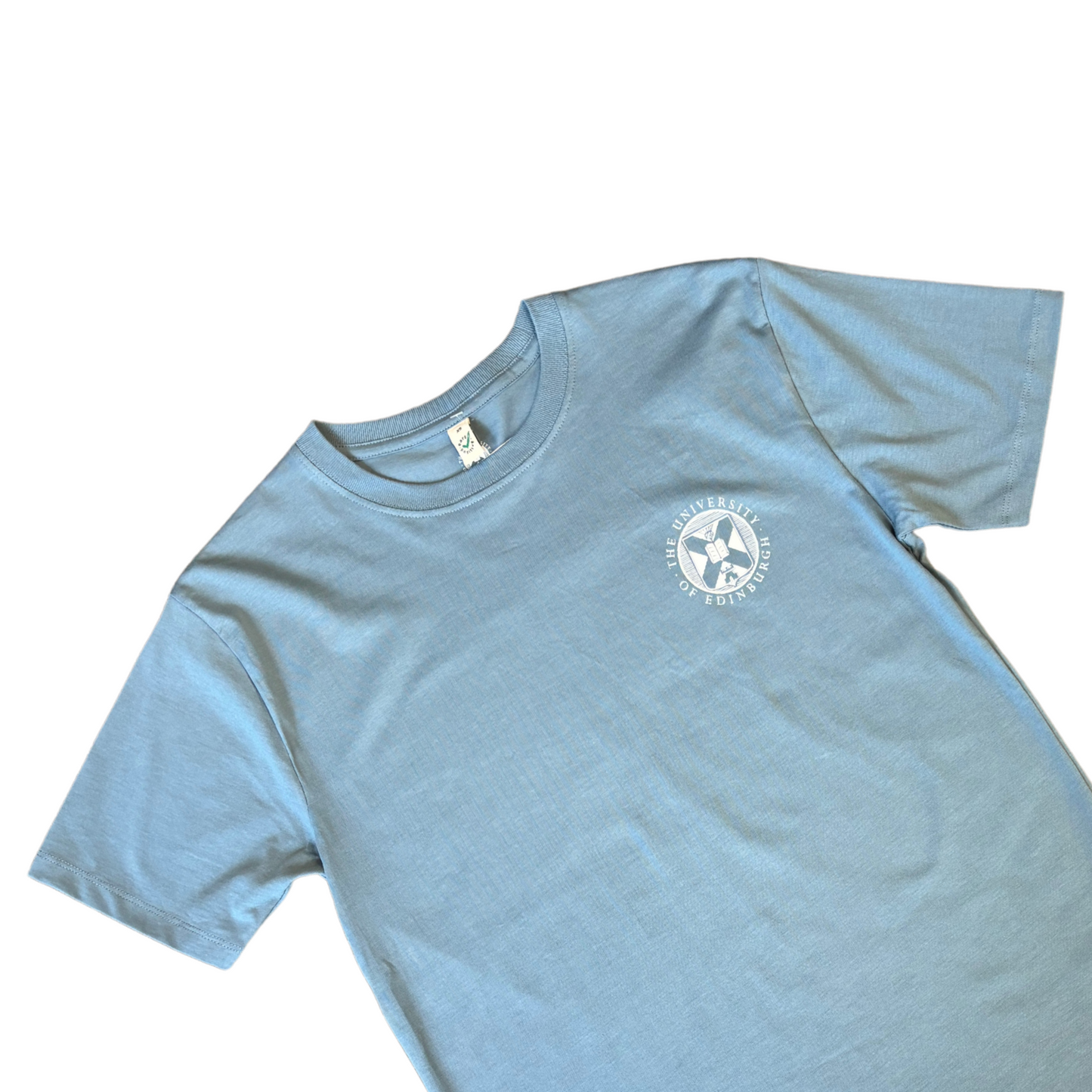 close up of a light blue t-shirt with the University crest printed in white.