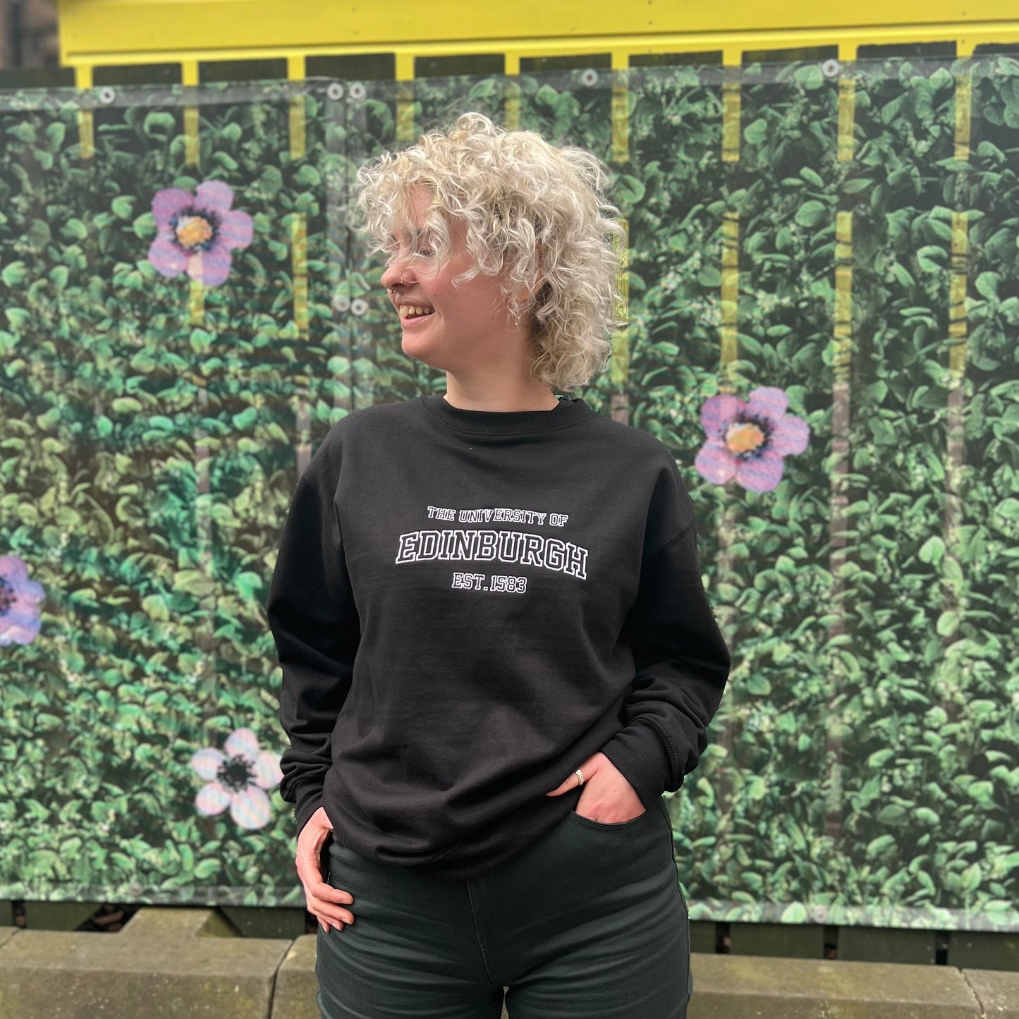 Our model wears the black pullover with white embroidery letters.