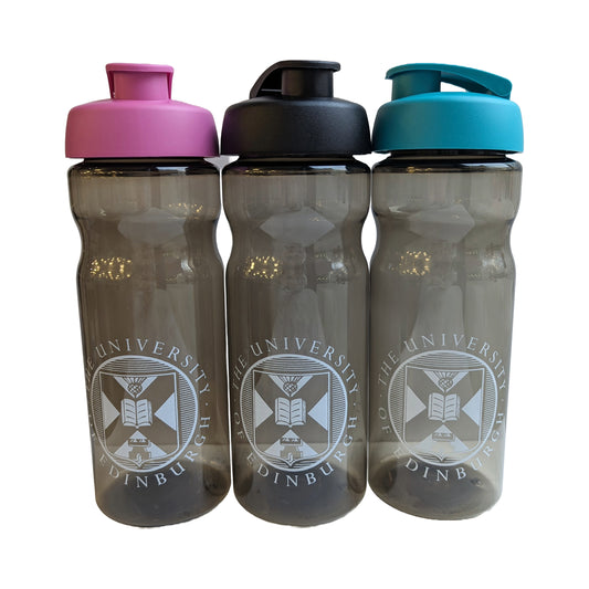 Three plastic dark grey water bottles in front of a white background. From left to right: a bottle with a white university crest and a pink cap, a bottle with the white university crest and a black cap, and a bottle with a white university crest a a blue/teal cap.