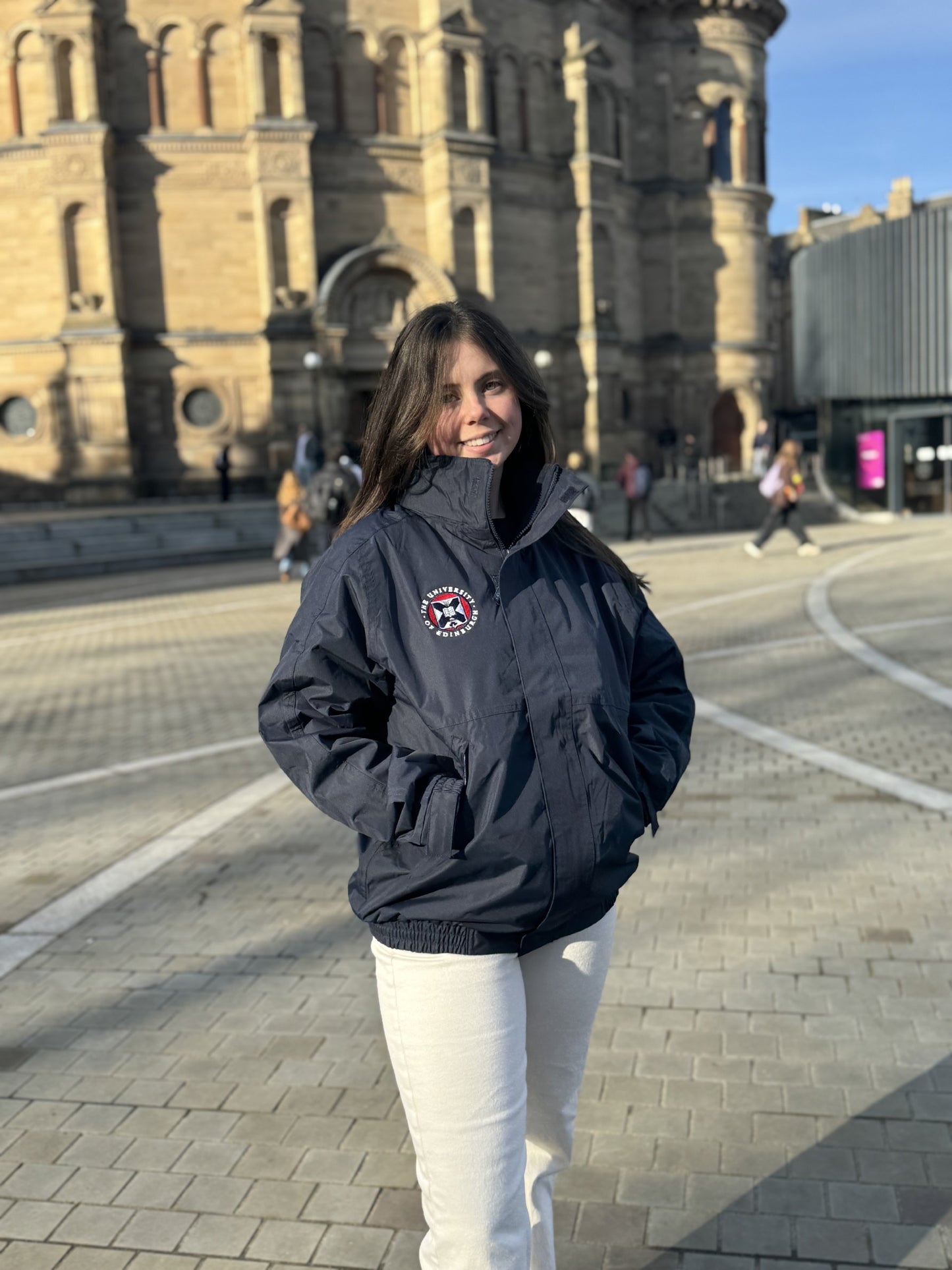 Model wears our navy Premium Outdoor Jacket which features a University Crest over the left chest, a high collar, elasticized cuffs and waistband, zipped pockets and a front zipper closure concealed by a protective flap.