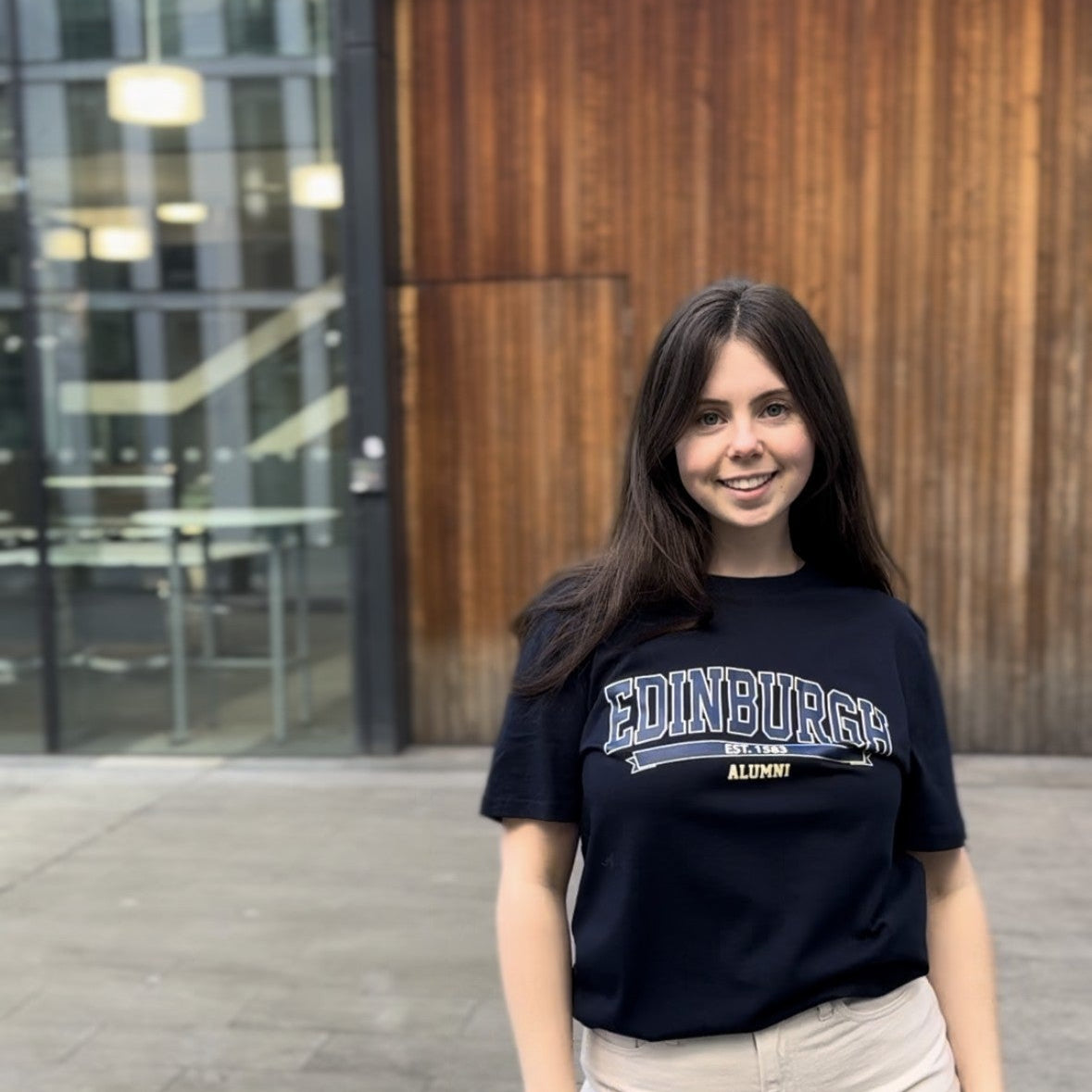 Model wears Navy T-shirt with 'EDINBURGH ALUMNI' text on the front in a lighter blue colour.