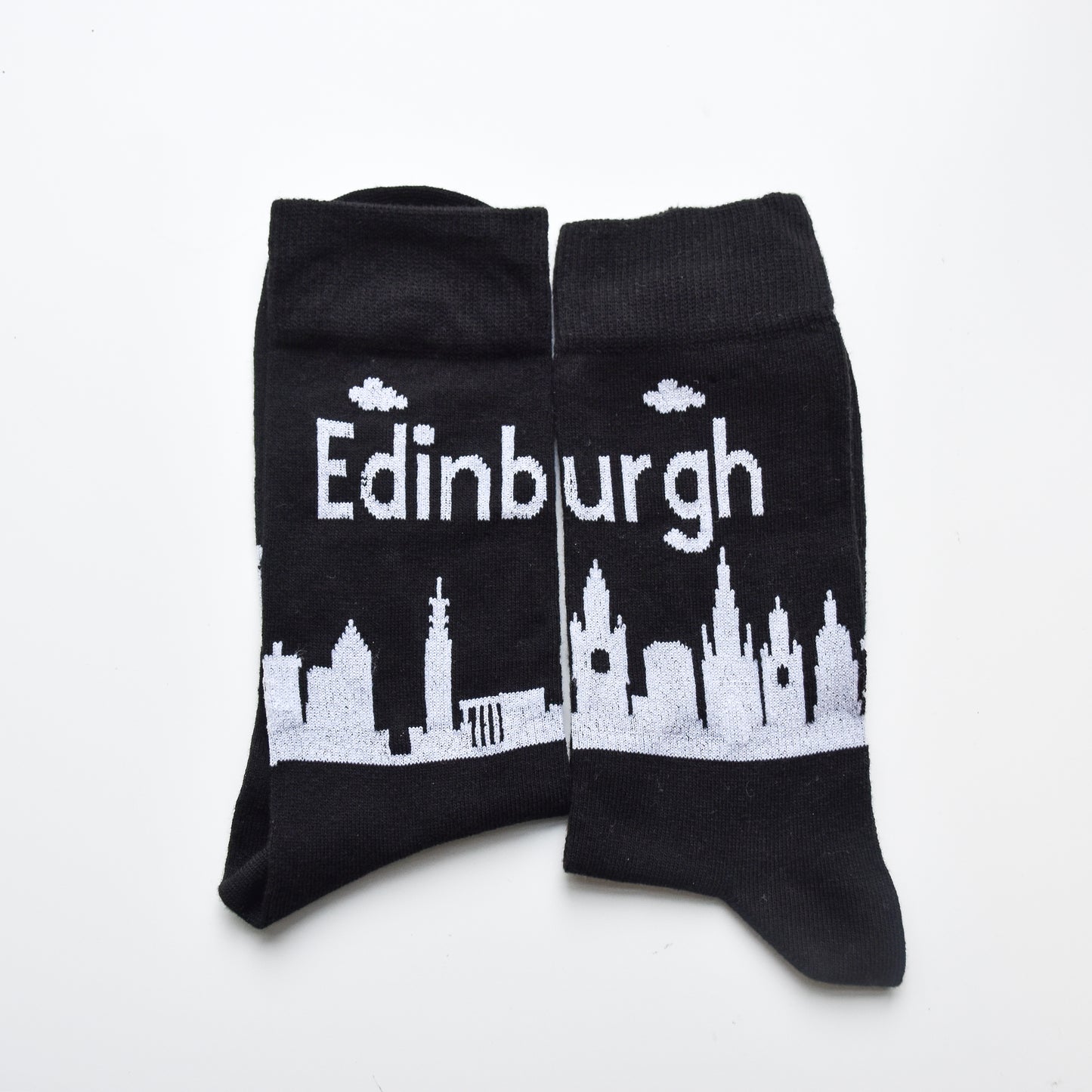 Black socks featuring the Edinburgh skyline in white print. 