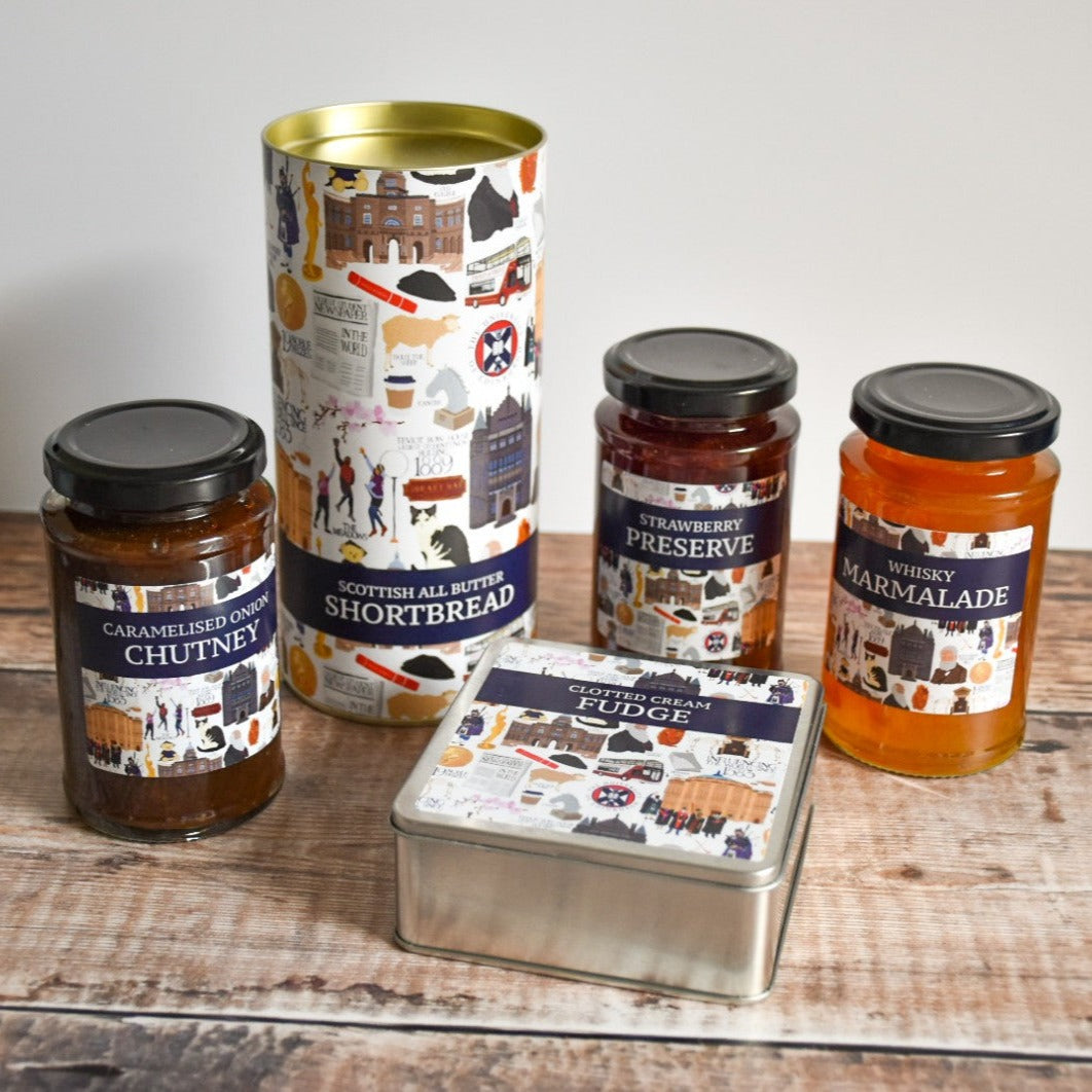 Collection of Clotted Cream Fudge, Scottish All Butter Shortbread, Caramelized Onion Chutney, Strawberry Preserve, and Whisky Marmalade containers.