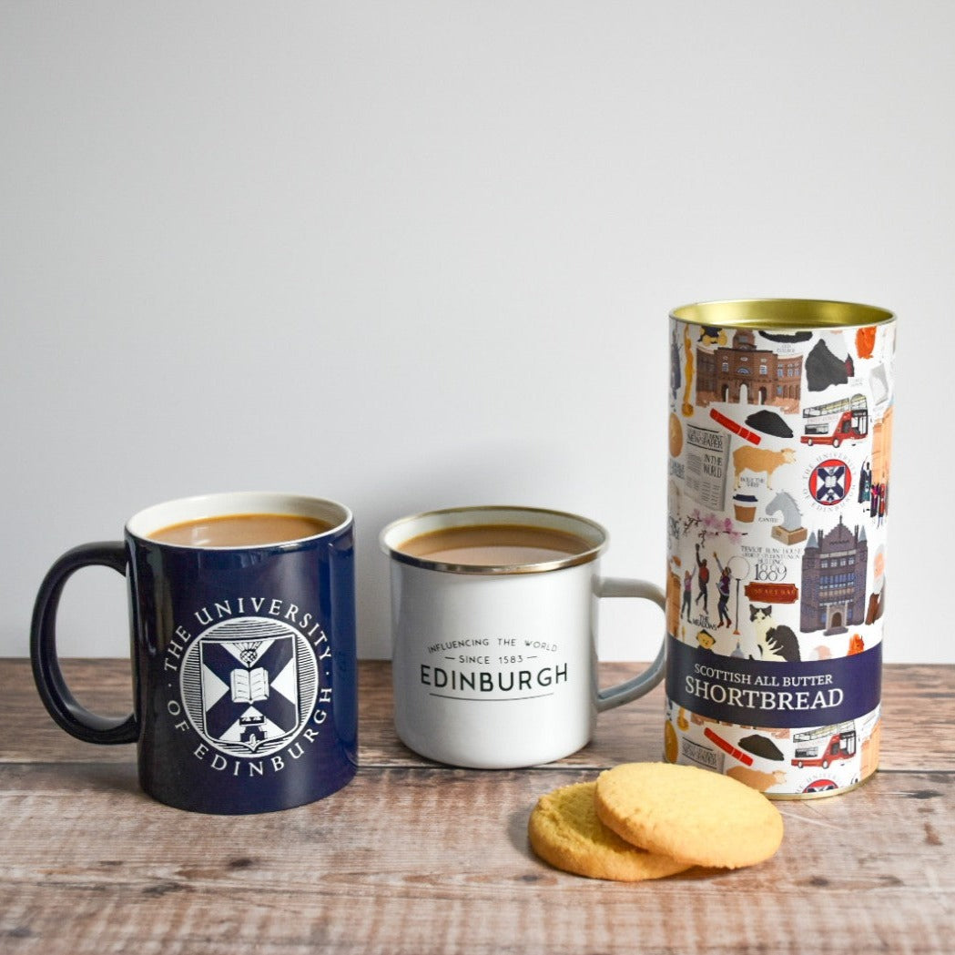 Scottish All Butter Shortbread cookies and container positioned next to two University of Edinburgh mugs filled with coffee