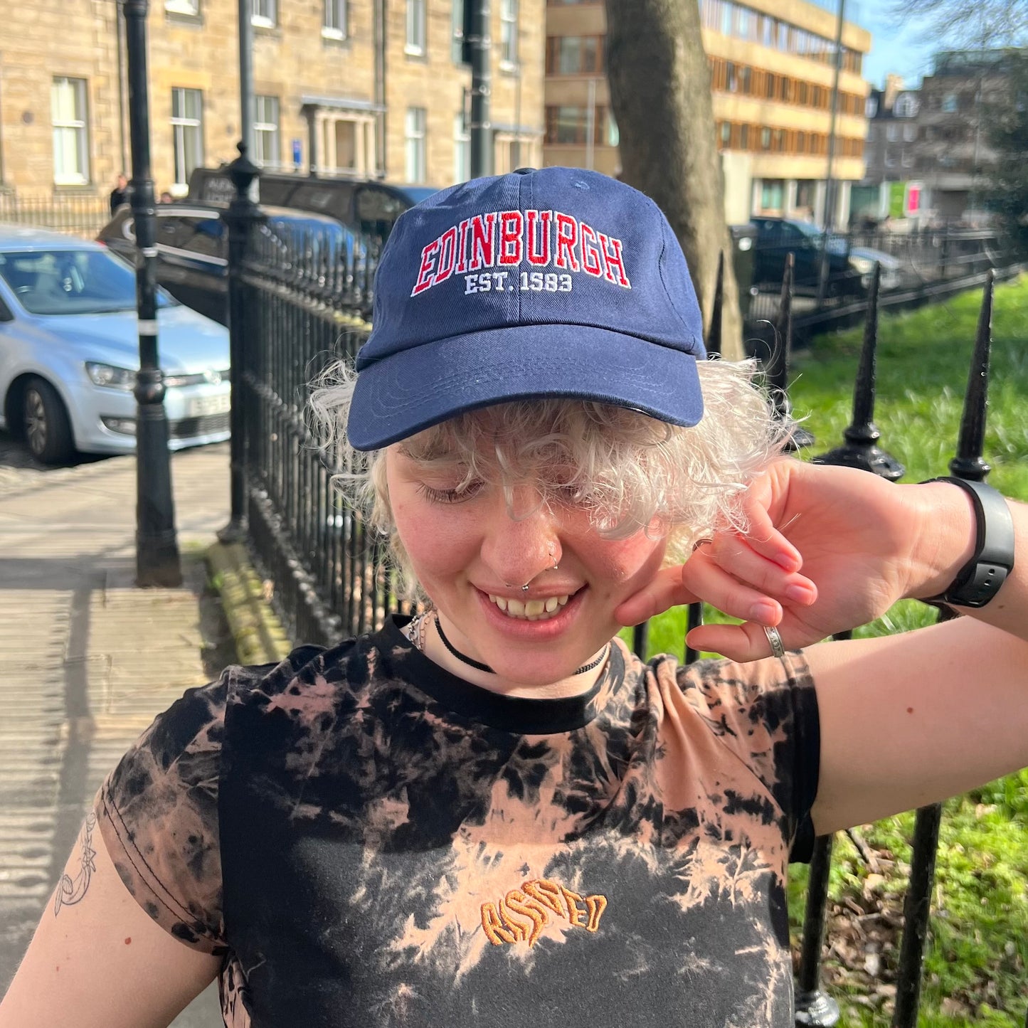 Model wears Navy baseball cap with red and white embriodered text stating 'EDINGBURGH'.