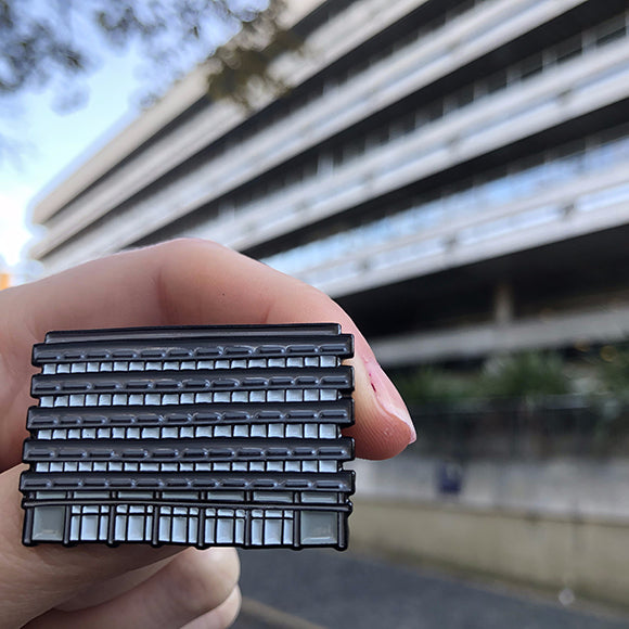 Main Library Pin Badge held in front of Main Library