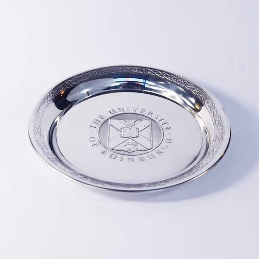 The pewter salver seen diagonally from above, with the University crest visible