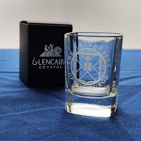 Crystal shot glass with University crest etching displayed in front of a Glencairn gift box.