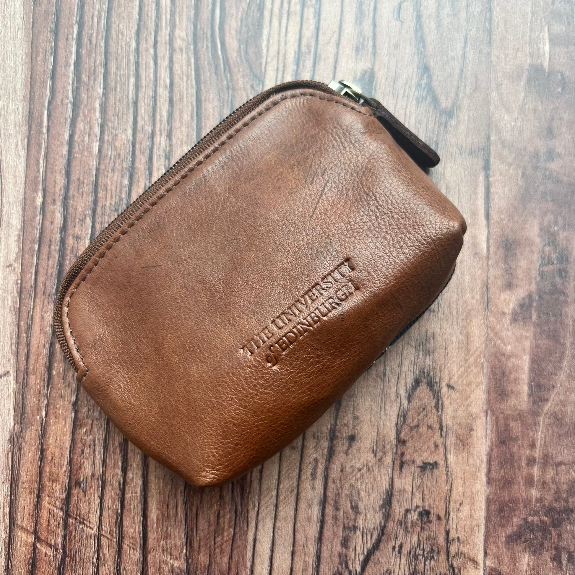 Leather side of coin purse with University logo embossed