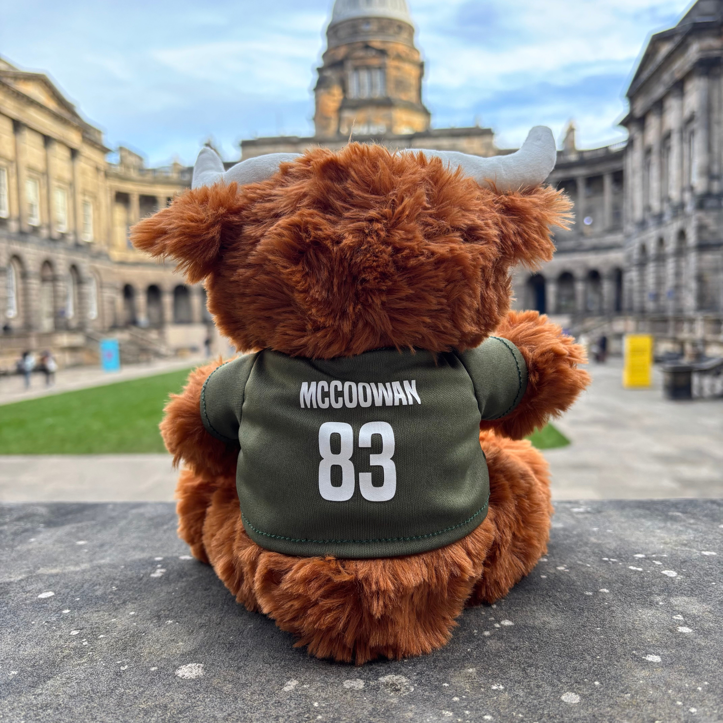 Plush Highland Coo with 'McCoowan 83' on the back of the shirt