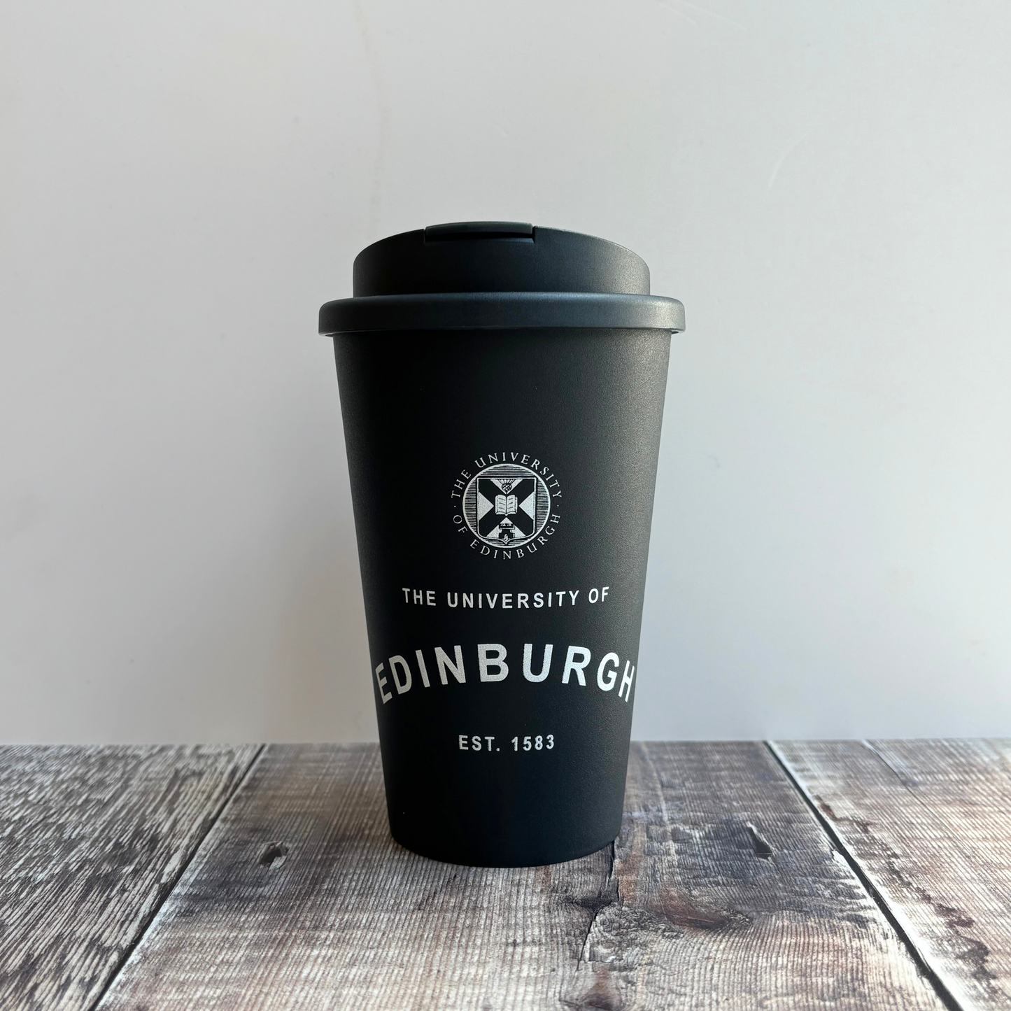 Eco Coffee Cup in black with screw-on flip-lid and 350 ml capacity. Features the University crest and our established print in white. 