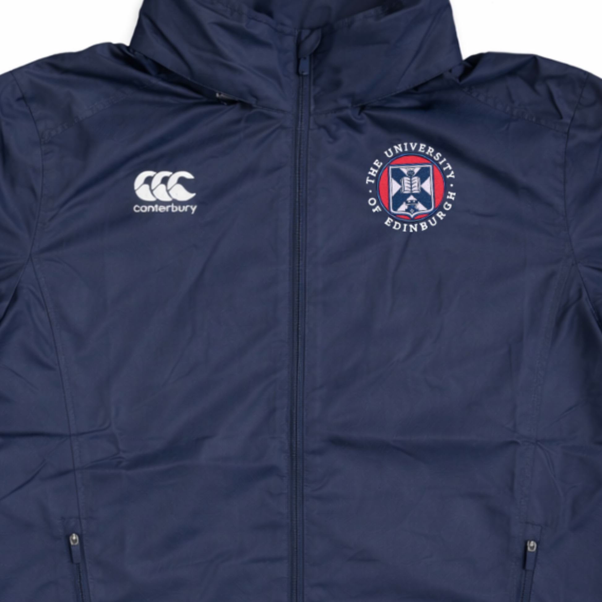 Close up of navy Vaposhield jacket with Canterbury logo on left chest and University of Edinburgh crest embroidered on the right chest.