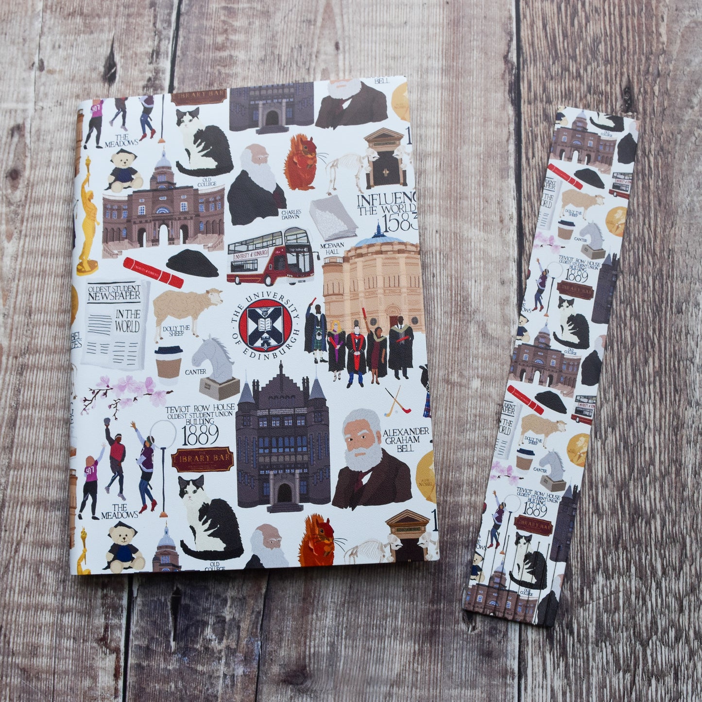 An A5 Heritage Collection Notebook and Heritage Collection bookmark placed side by side on a warm brown wooden background.