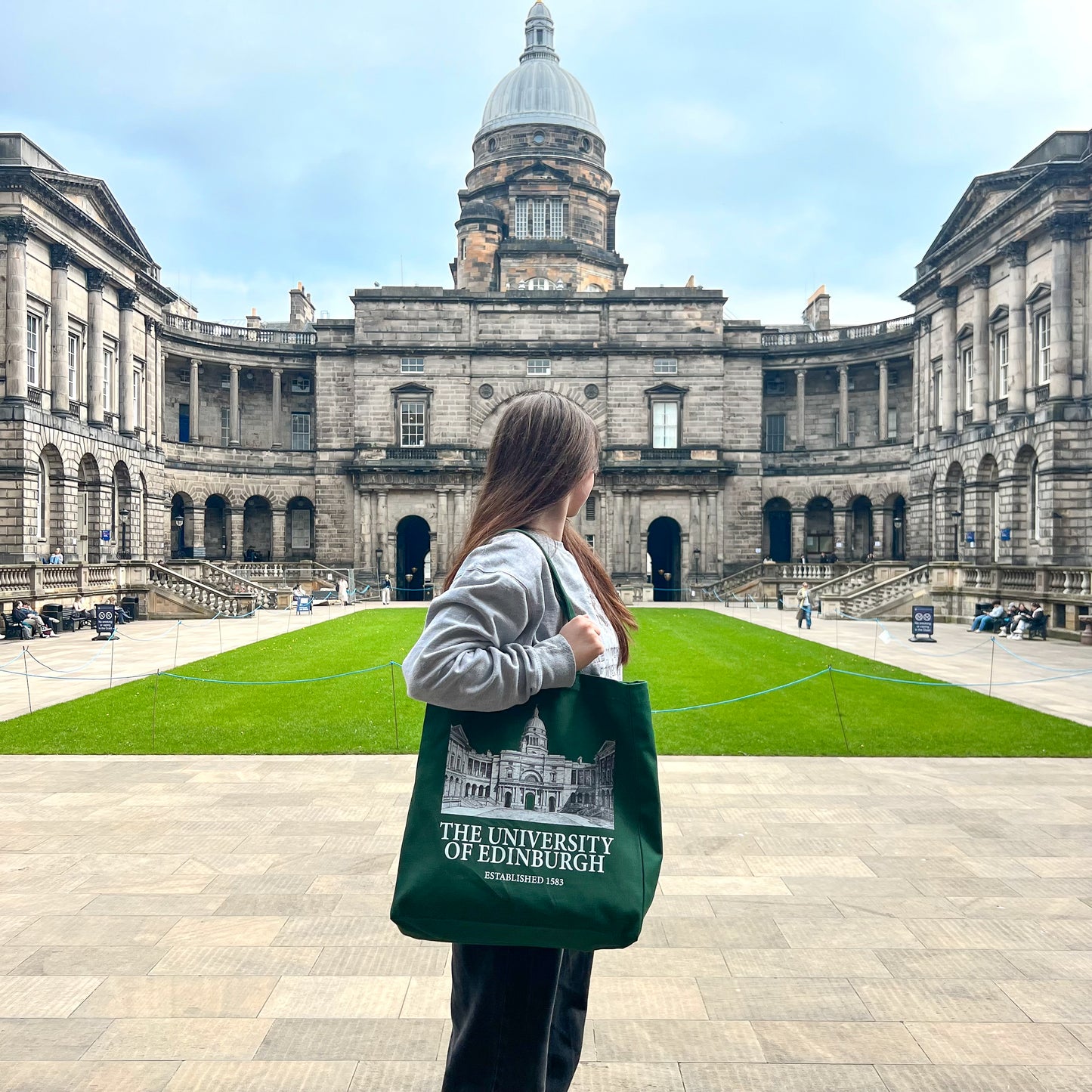 Our model wears the Old College tote bag while standing in the actual Old College courtyard.