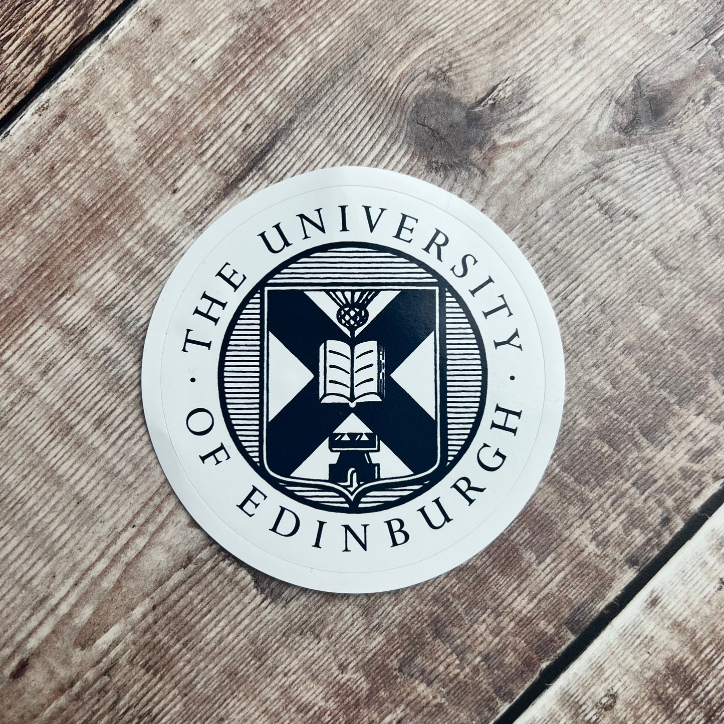 Laptop sticker with navy university crest on white background