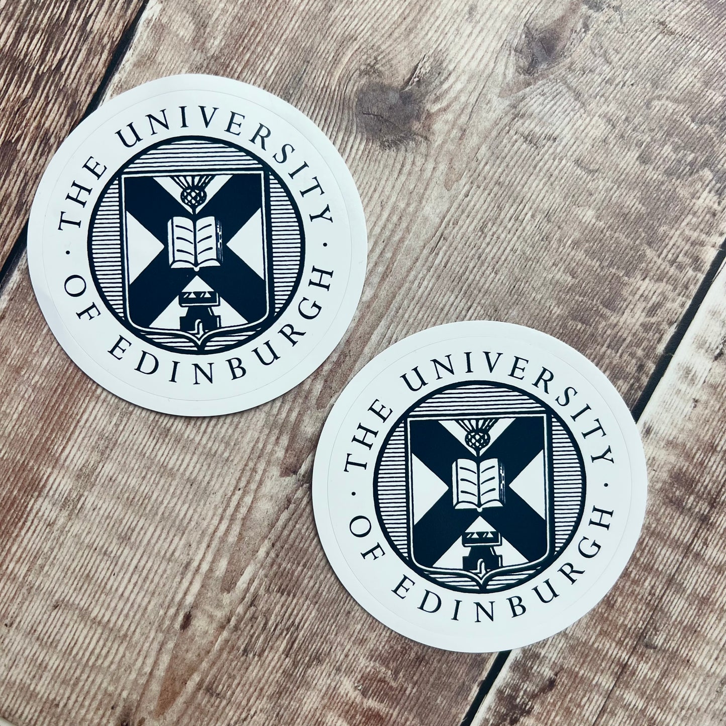 2 laptop stickers with navy university crest on white background