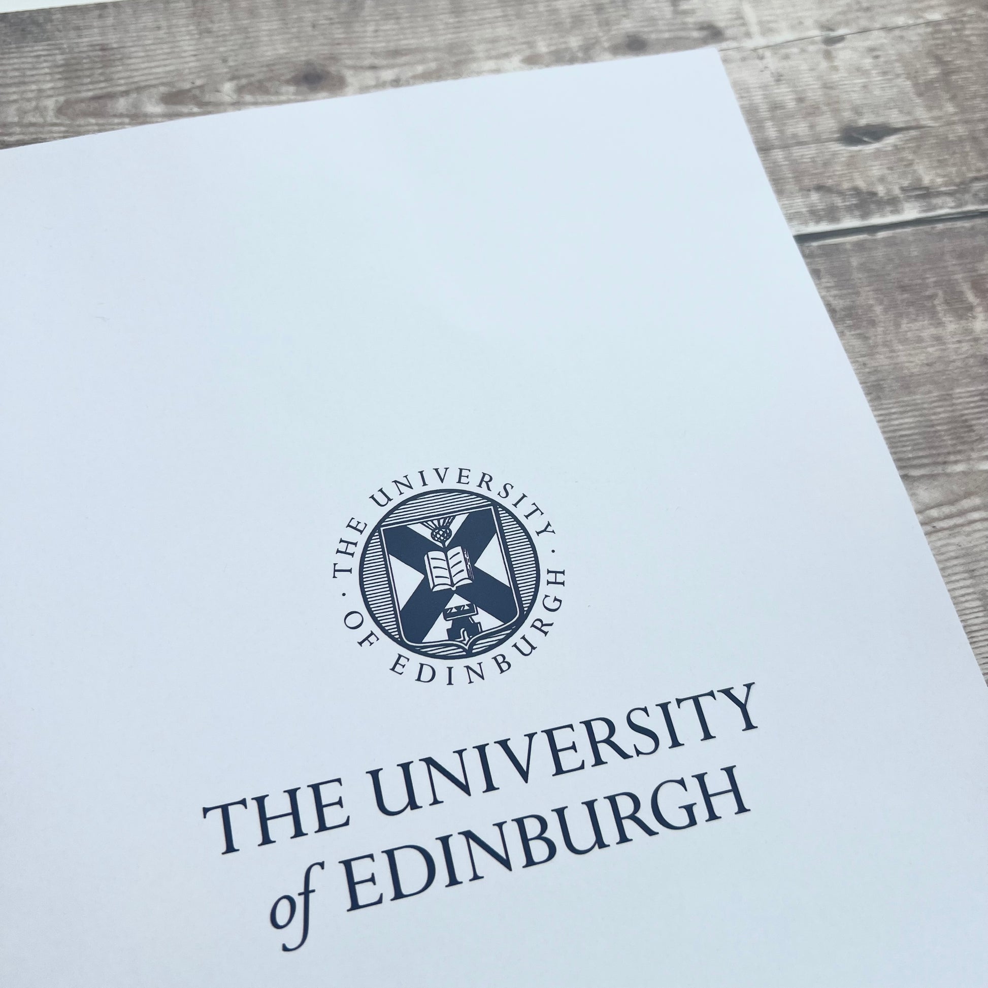 close ip of White a4 notebook cover featuring University crest and name in navy