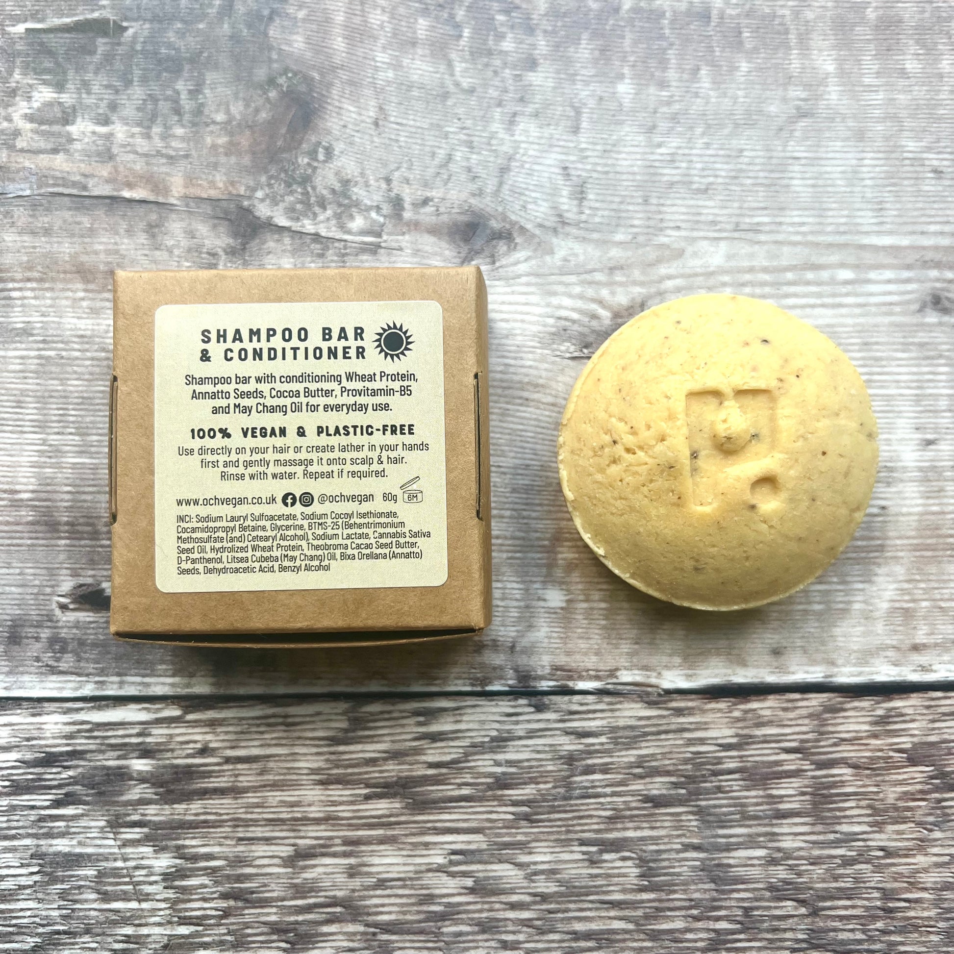 ROUND yellow shampoo bar next to back of brown paper box 