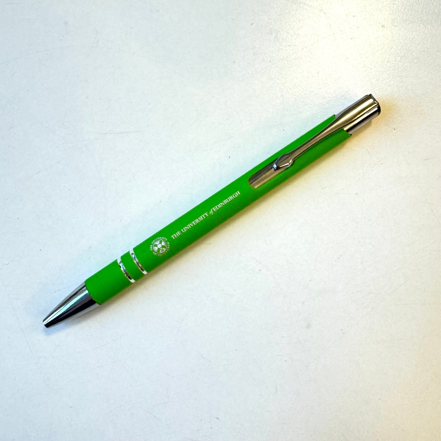 green soft rubber pen with silver university crest and with black ink