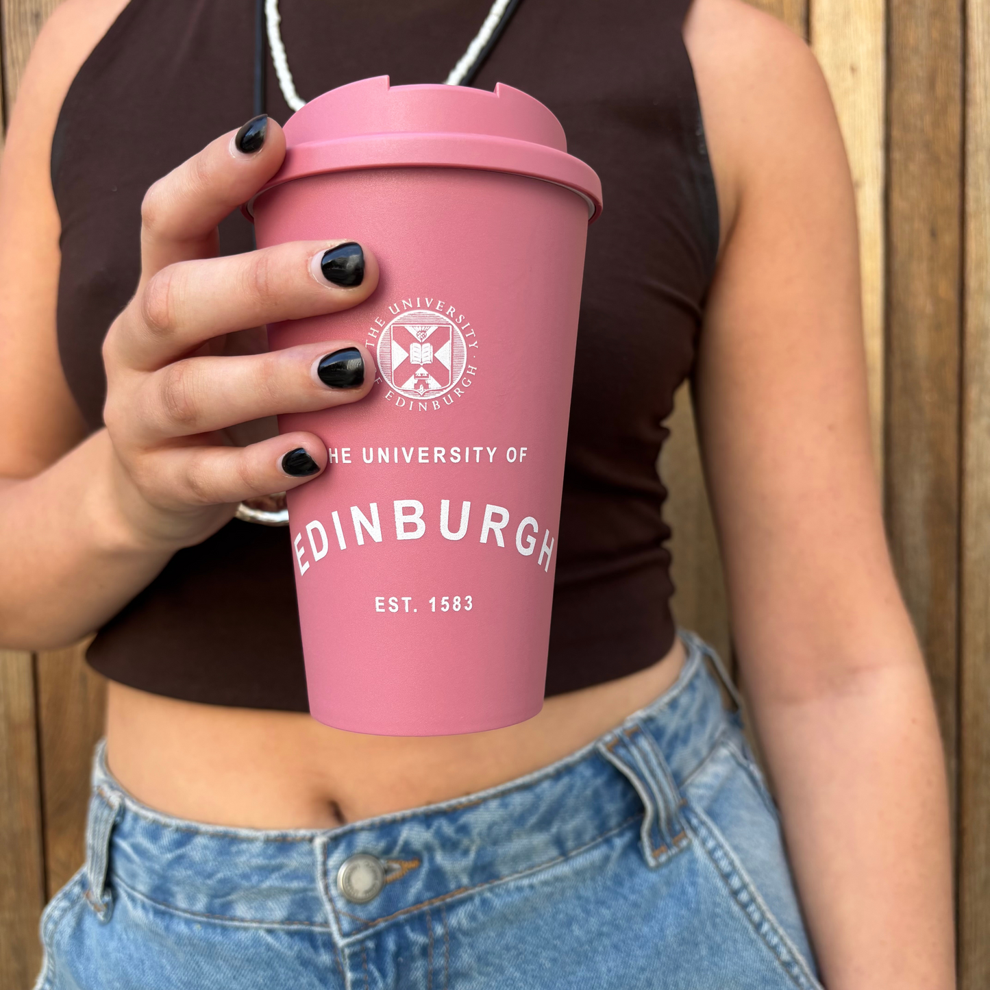 Model carries the Eco Coffee Cup in raspberry.