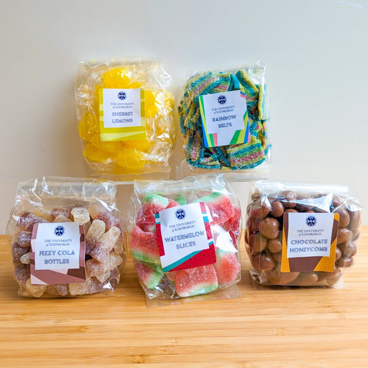 Assortment of 5 different sweets bags, including Sherbet Lemons, Rainbow Belts, Fizzy Cola Bottles, Watermelon Slices, and Chocolate Honeycomb.