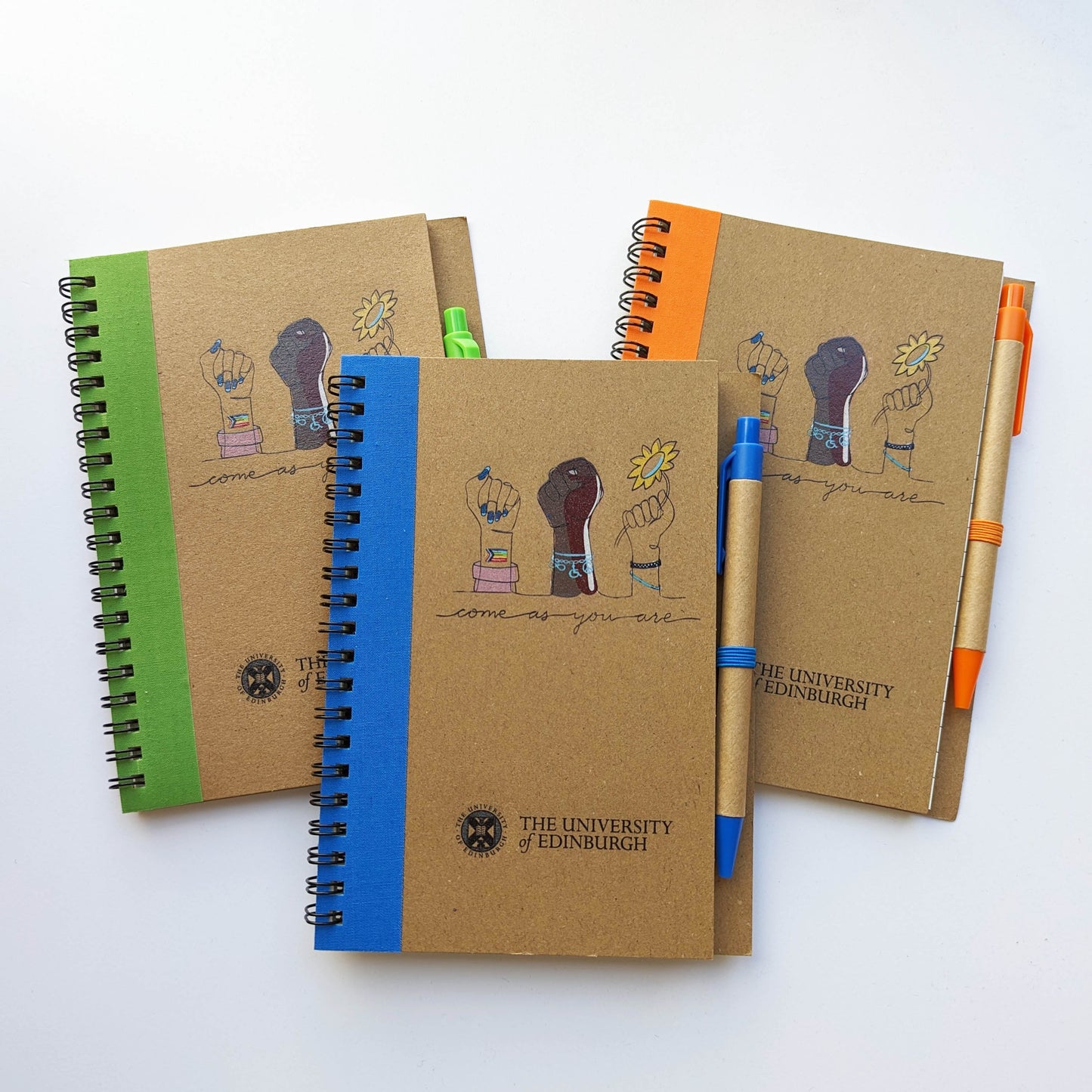 Come as You Are Notebooks with pens - available in three colour bands: blue, green and orange. Design on front are three different hands representing the staff networks diversity: race, gender, sexuality and disability.