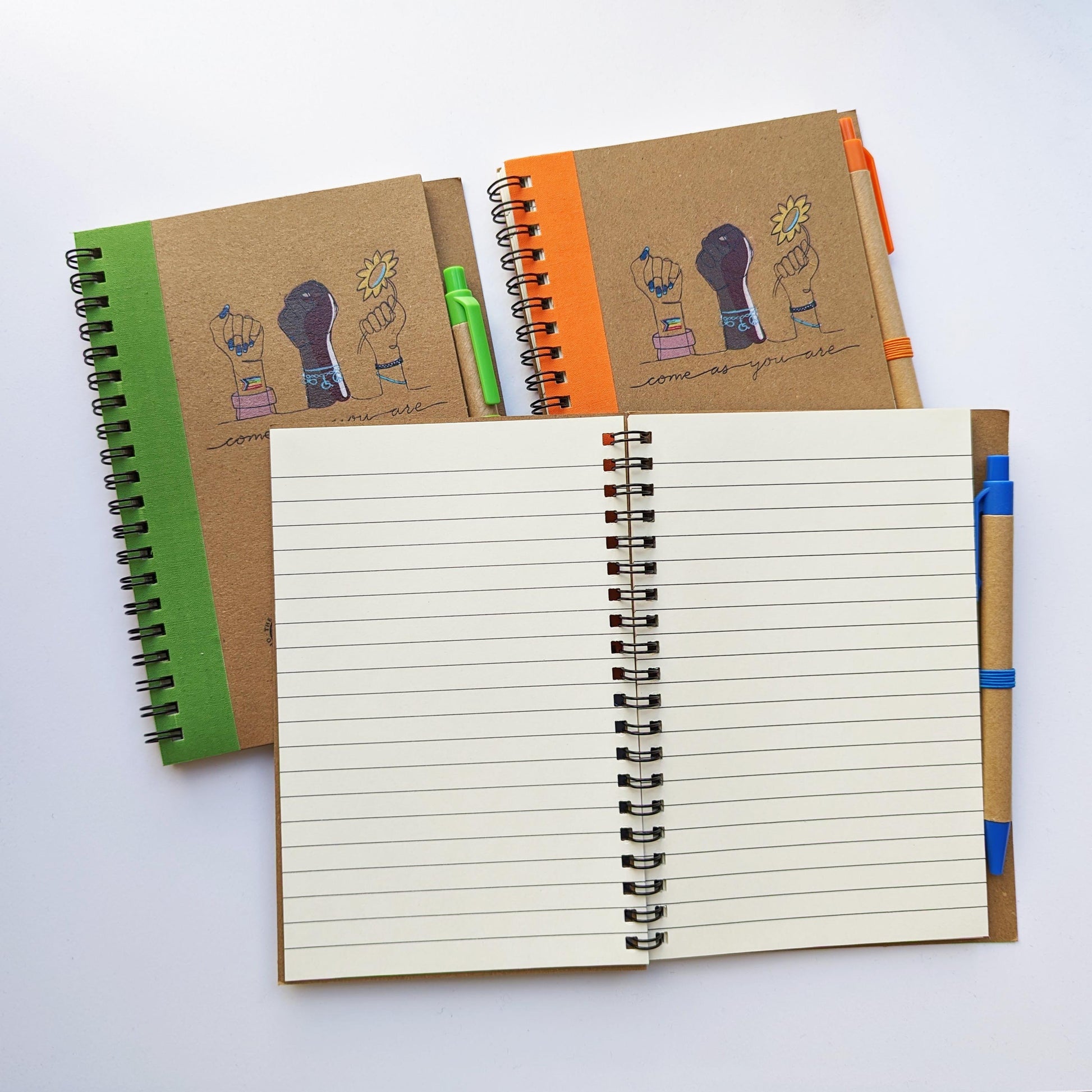 The three notebooks pictured with one open showing lined pages.