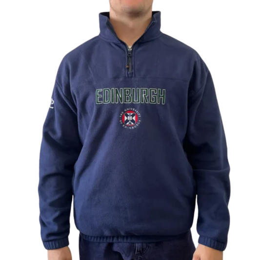 Navy fleece oversized 1/4 zip sweatshirt with 'EDINBURGH' embroidered in green with a white outline, on top of a embroidered full colour crest. A 'PL' is embroidered in white on the right sleeve. The cuffs and waistband of the pullover is cuffed.