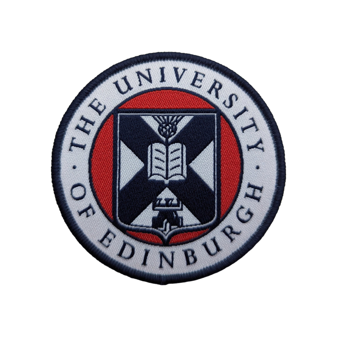 close up of the white, red, and navy woven university crest patch on a white background