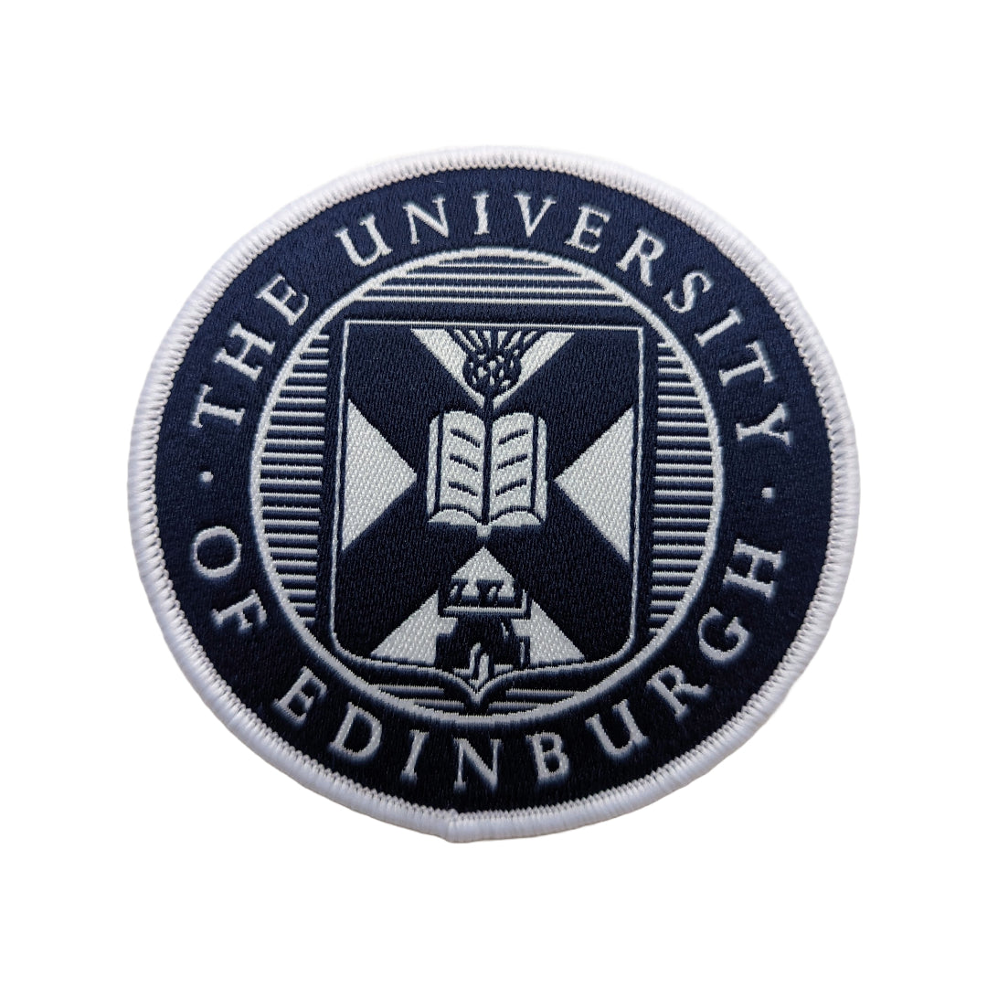 close up of navy and white woven university crest patch on a white background