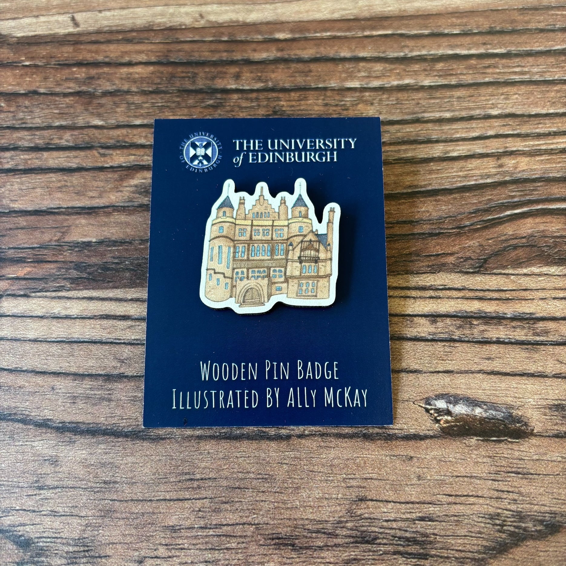 The Teviot Row House wooden pin badge on its backing card.